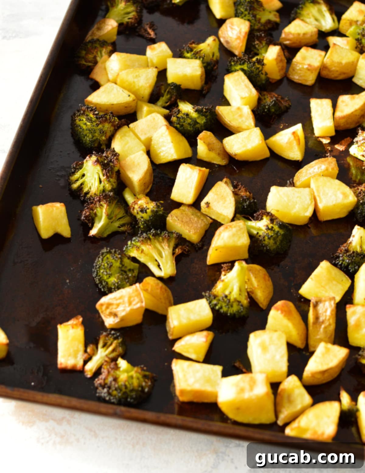 roasted potatoes with broccoli on a sheet pan. 