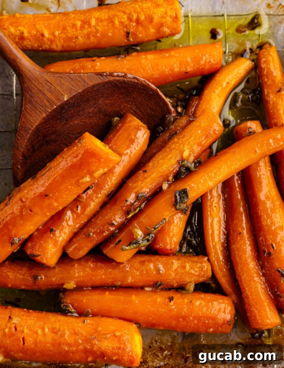 Maple-Glazed Roasted Carrots 11 roasted carrots in a baking dish with a wooden spoon.