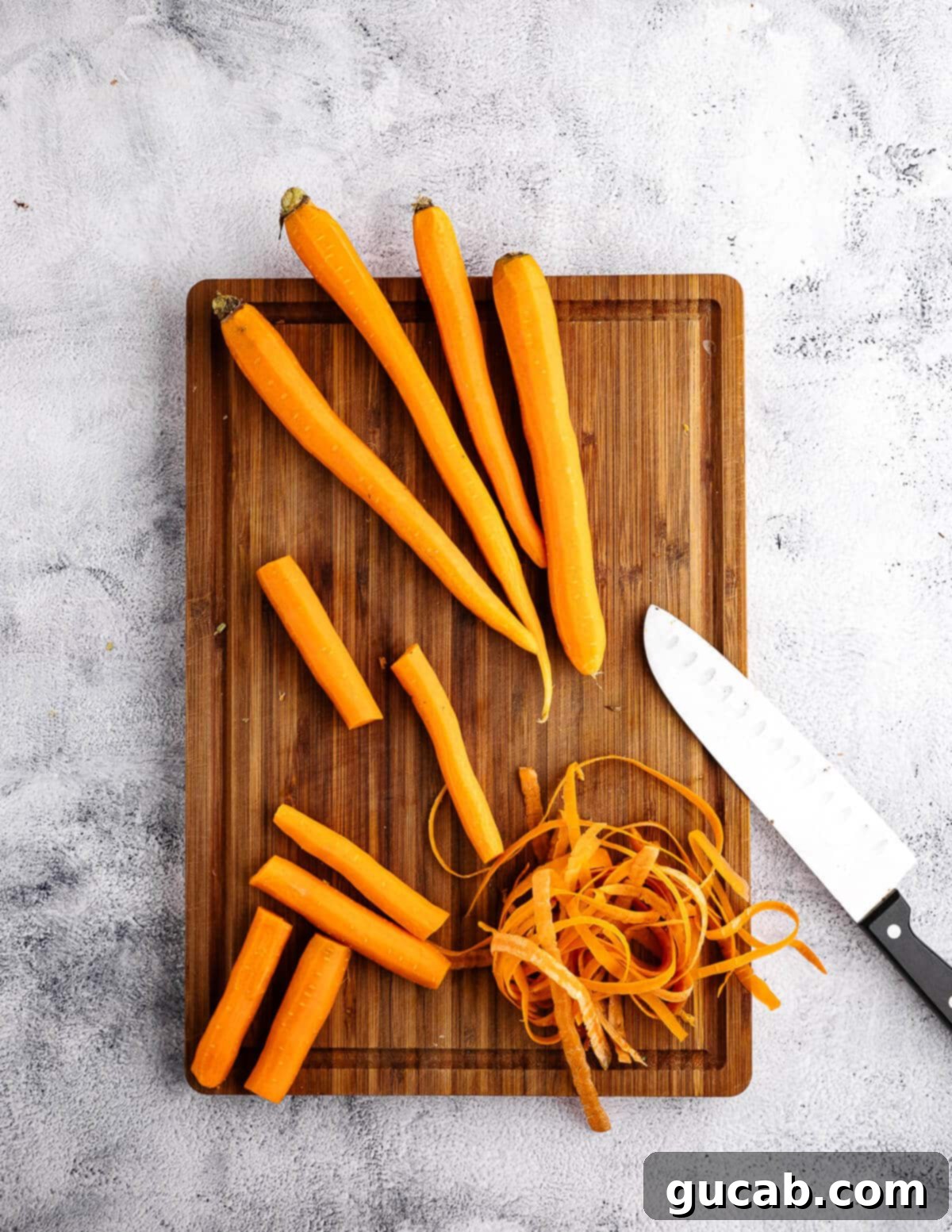 Maple-Glazed Roasted Carrots 6 peeled and cut carrots on a cutting board.