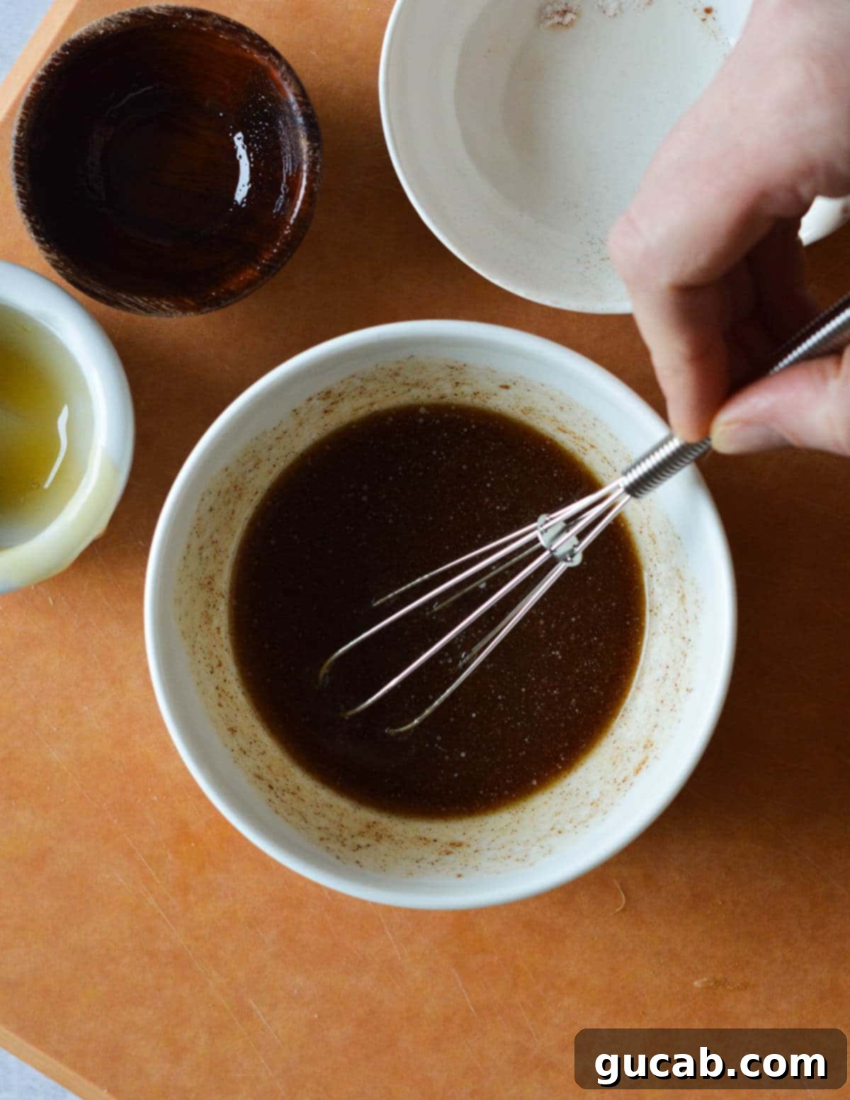 A small bowl of honey, olive oil, cinnamon, and butter, perfectly whisked together to form a smooth glaze.