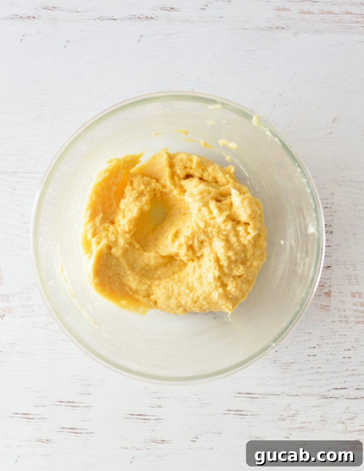 The butter, sugars, and eggs are fully creamed and mixed in a bowl, creating a smooth, cohesive wet mixture.