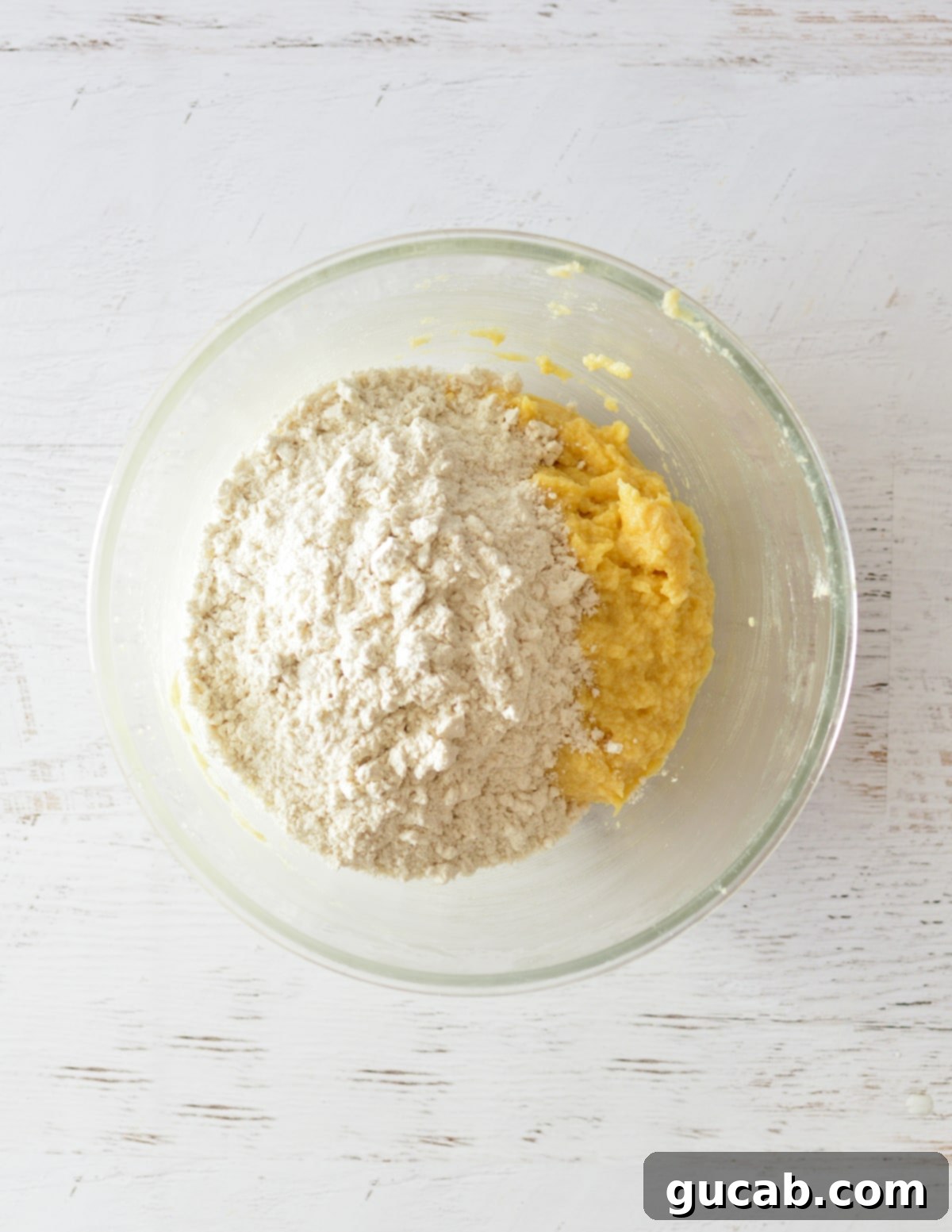 The wet ingredients in the bowl, with flour, baking soda, and salt added on top, before being mixed into dough.
