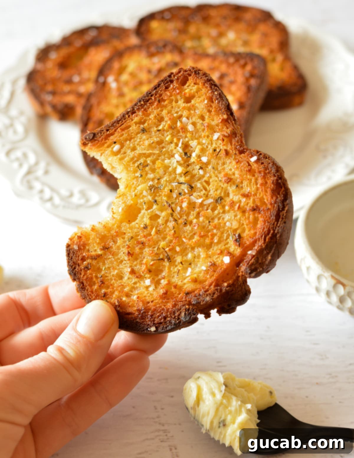 A perfectly golden-brown slice of homemade garlic bread, lightly toasted and seasoned.