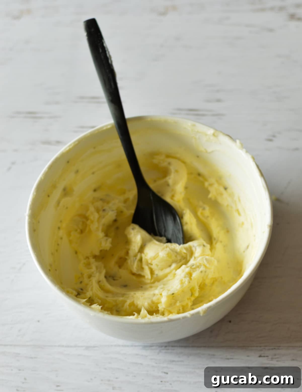 A bowl of freshly prepared, smooth garlic butter mixture.