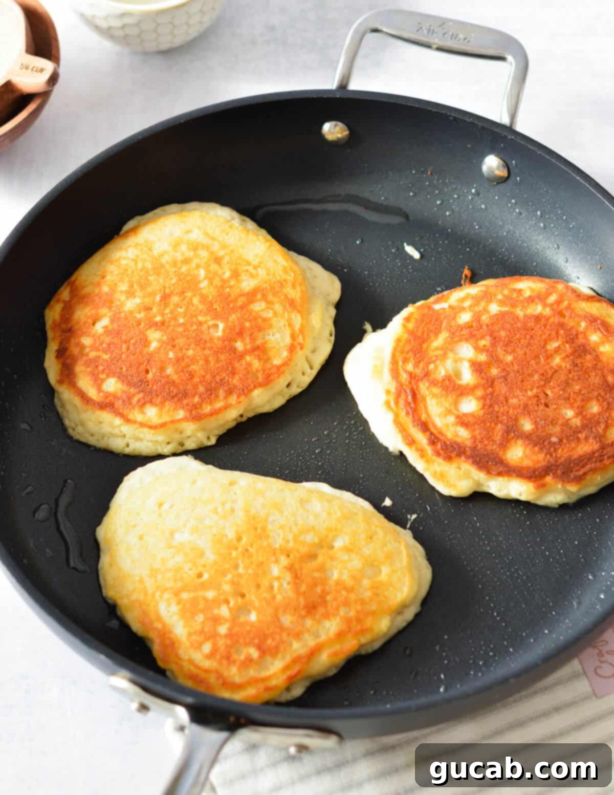 golden brown pancakes cooking in a skillet.