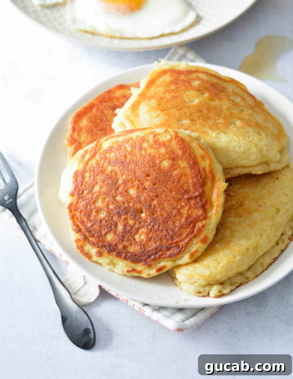 a plate of perfectly cooked buttermilk pancakes ready to be served.