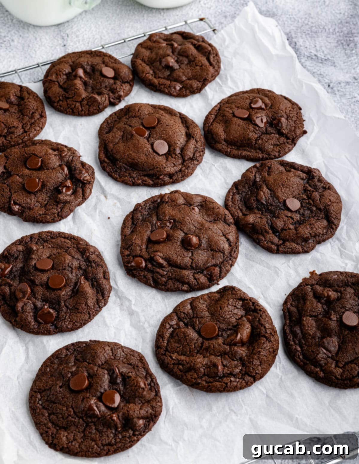 Freshly baked gluten-free double chocolate cookies cooling on a parchment-lined baking sheet.
