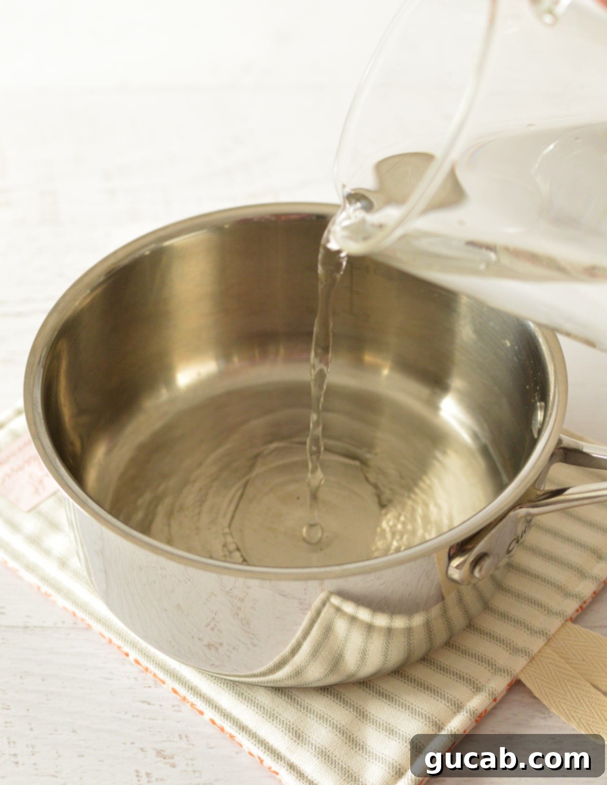 A hand pouring water into a small saucepan on a stovetop, preparing to bring it to a boil for oatmeal.