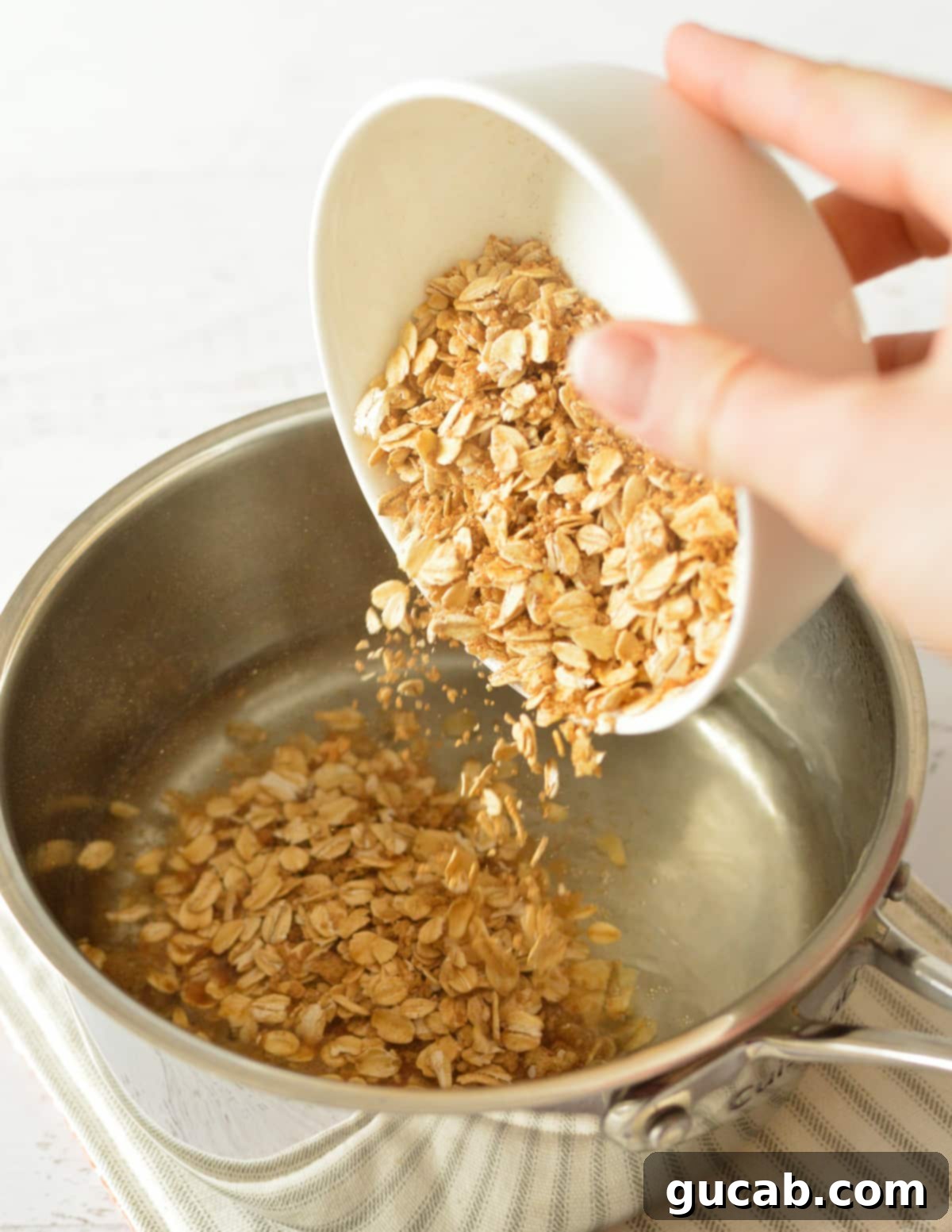 The oat mixture being poured into a saucepan of boiling water, about to be stirred and cooked.
