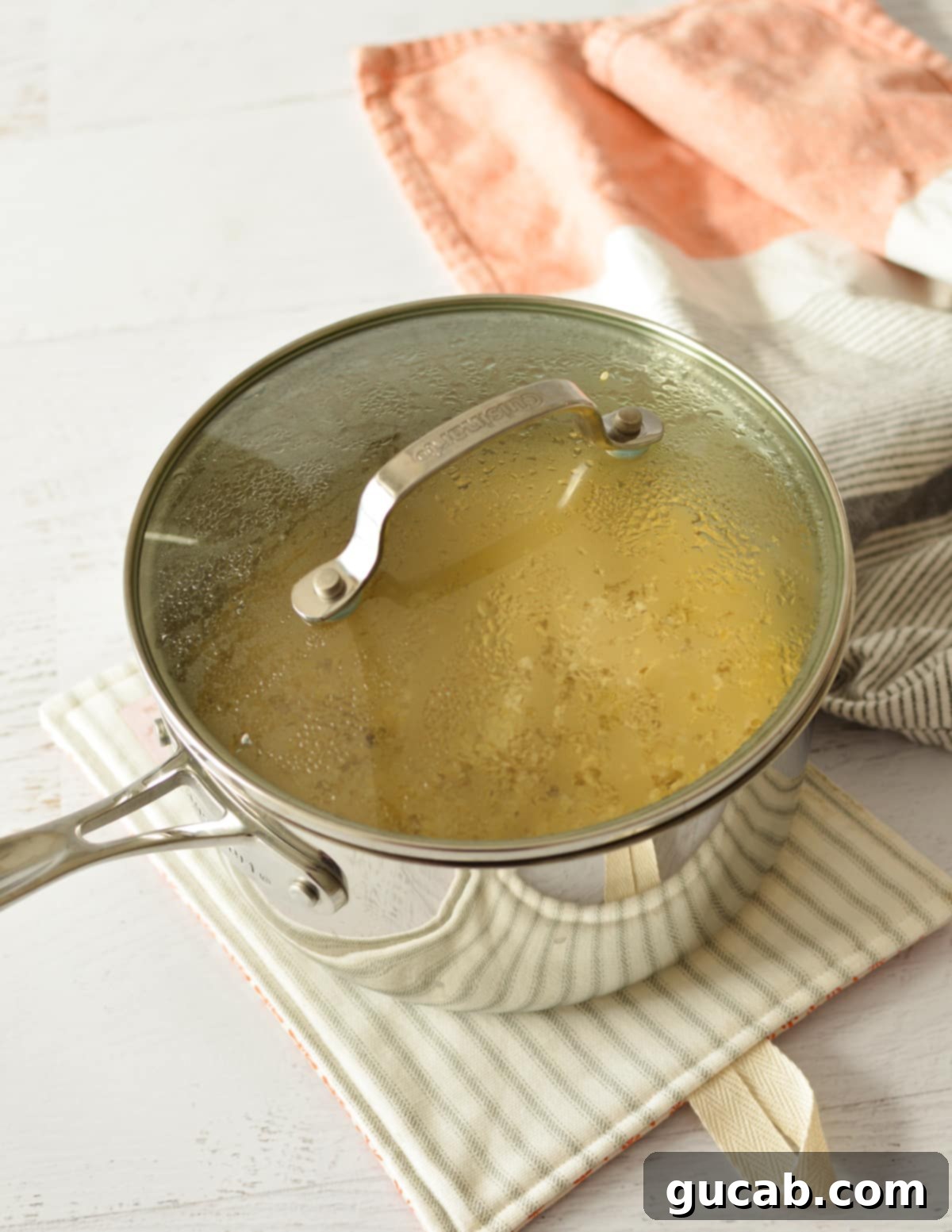 A saucepan filled with cooked oatmeal, covered with a lid, resting on the stovetop.