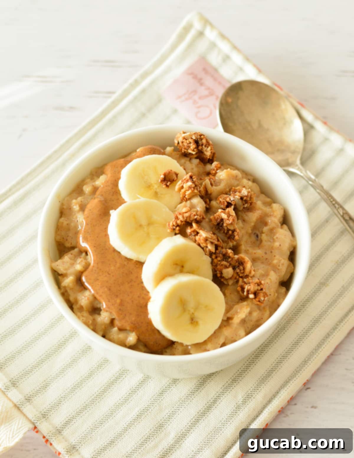 Almond Butter Bliss Bowl 2 a bowl of oatmeal with almond butter, bananas, and granola.