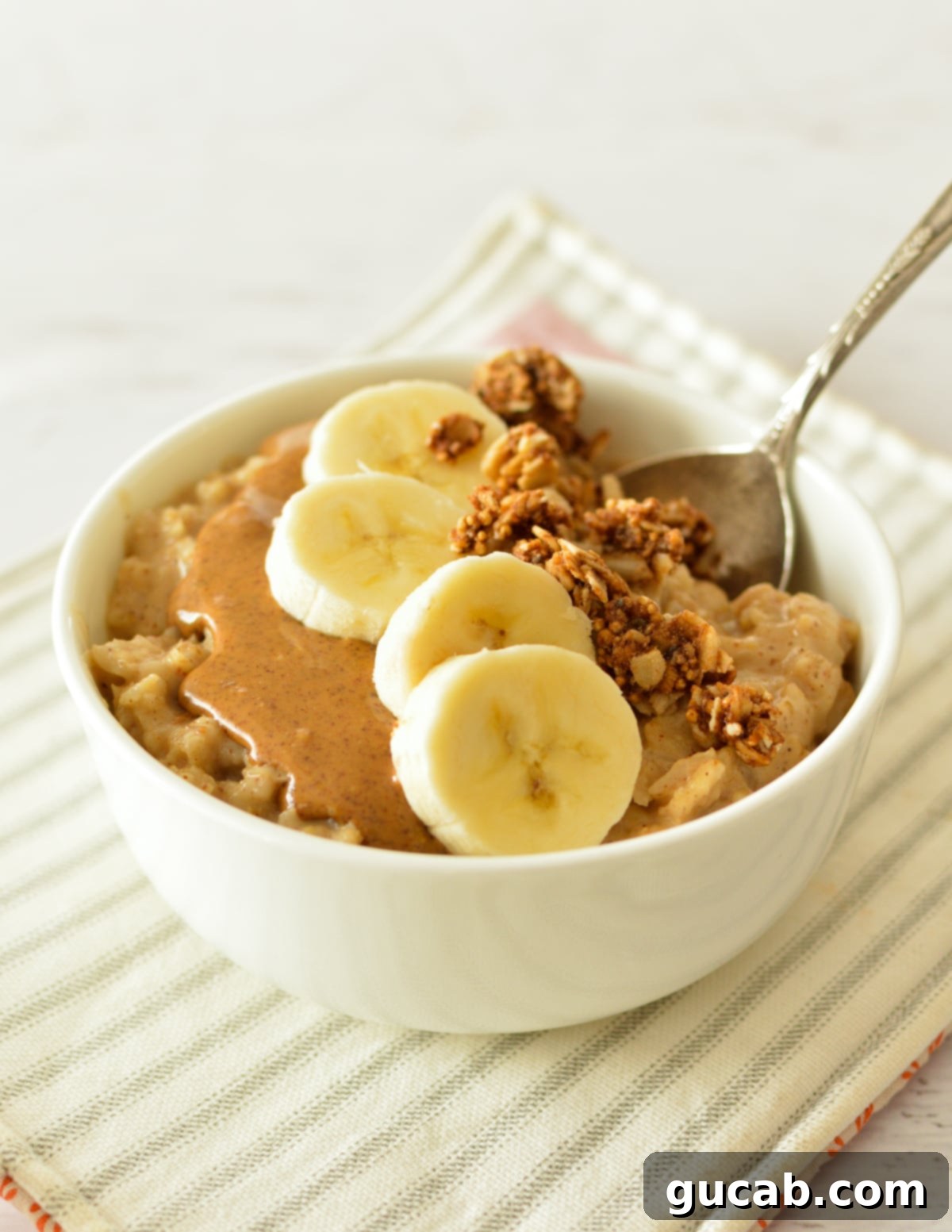 Almond Butter Bliss Bowl 10 a bowl of oatmeal with bananas and almond butter on top.