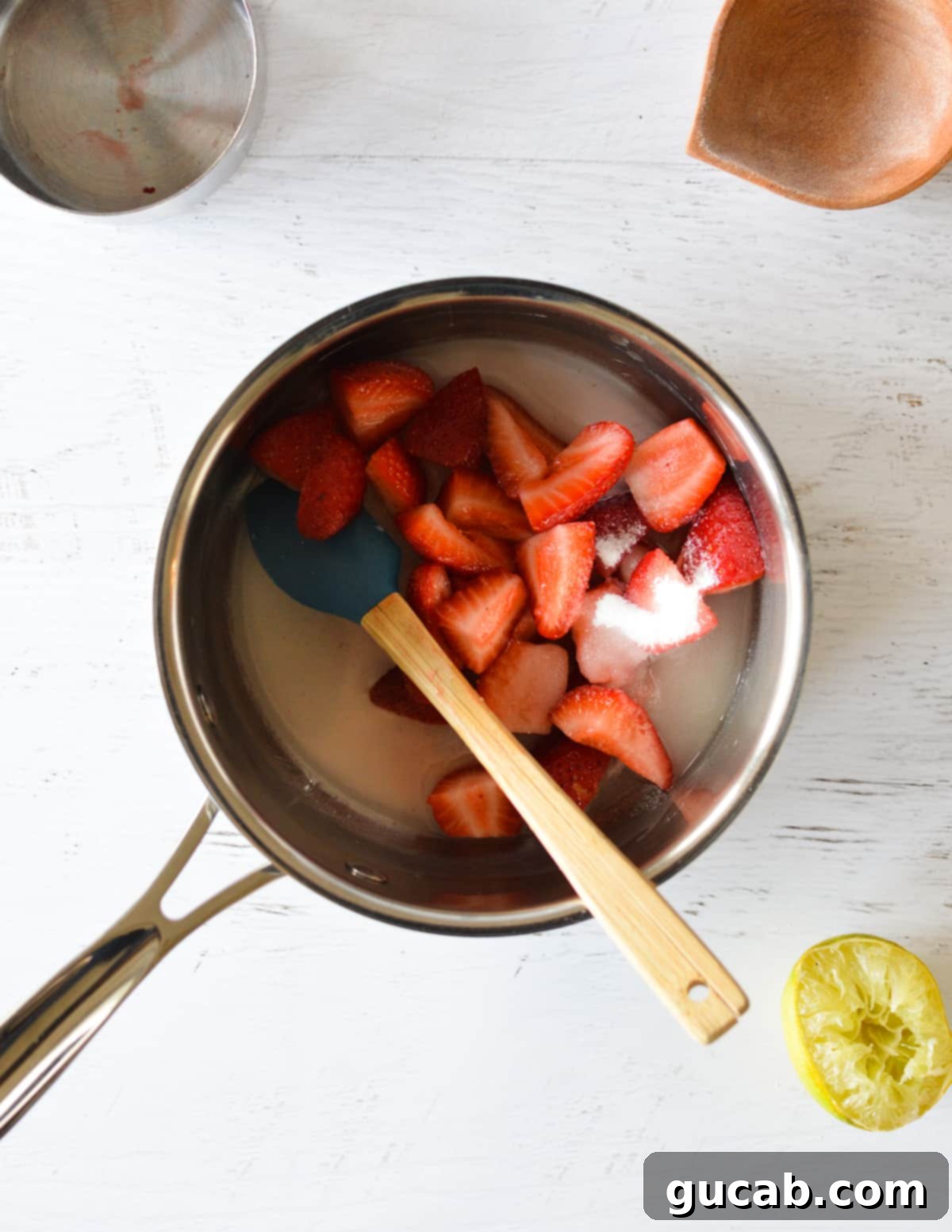 Strawberries, sugar, and cornstarch mixture added to a pan.