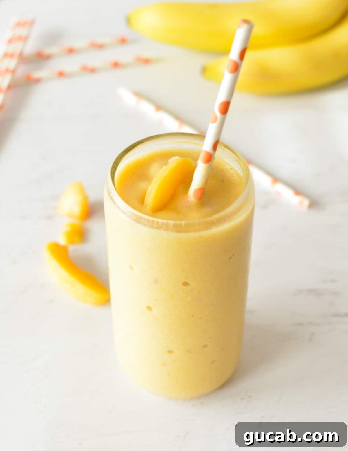 Sweet Chill: 15 Irresistible Frozen Peach Recipes 16 a peach smoothie with a straw.