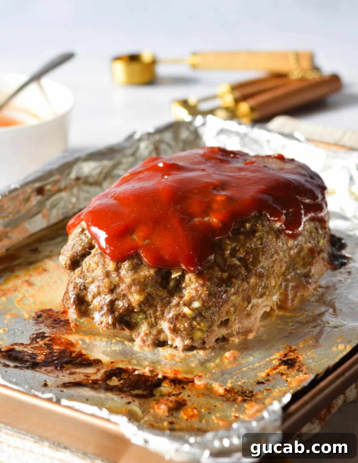 baked meatloaf on a sheet pan with ketchup glaze.