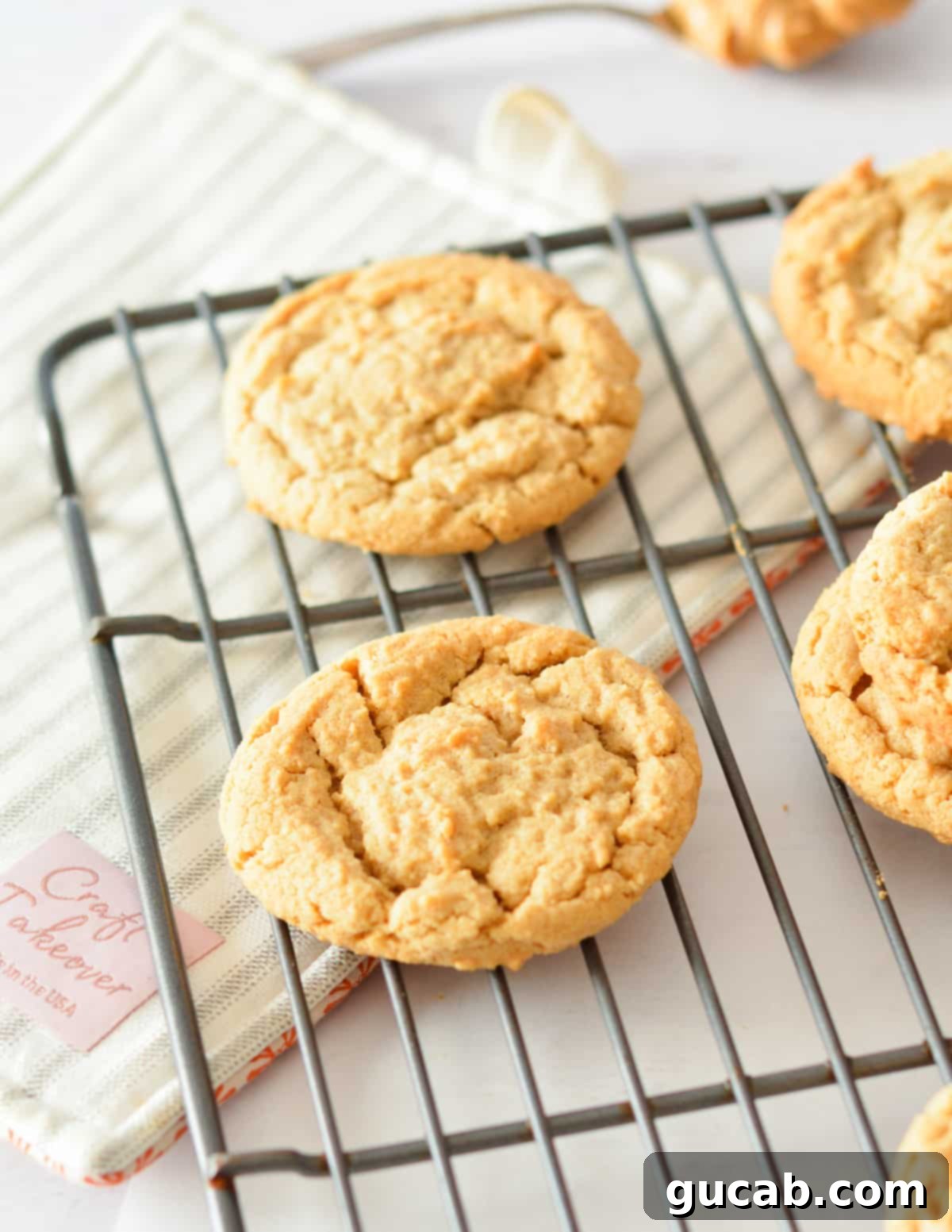 Freshly baked soft and chewy peanut butter cookies cooling on a wire rack.