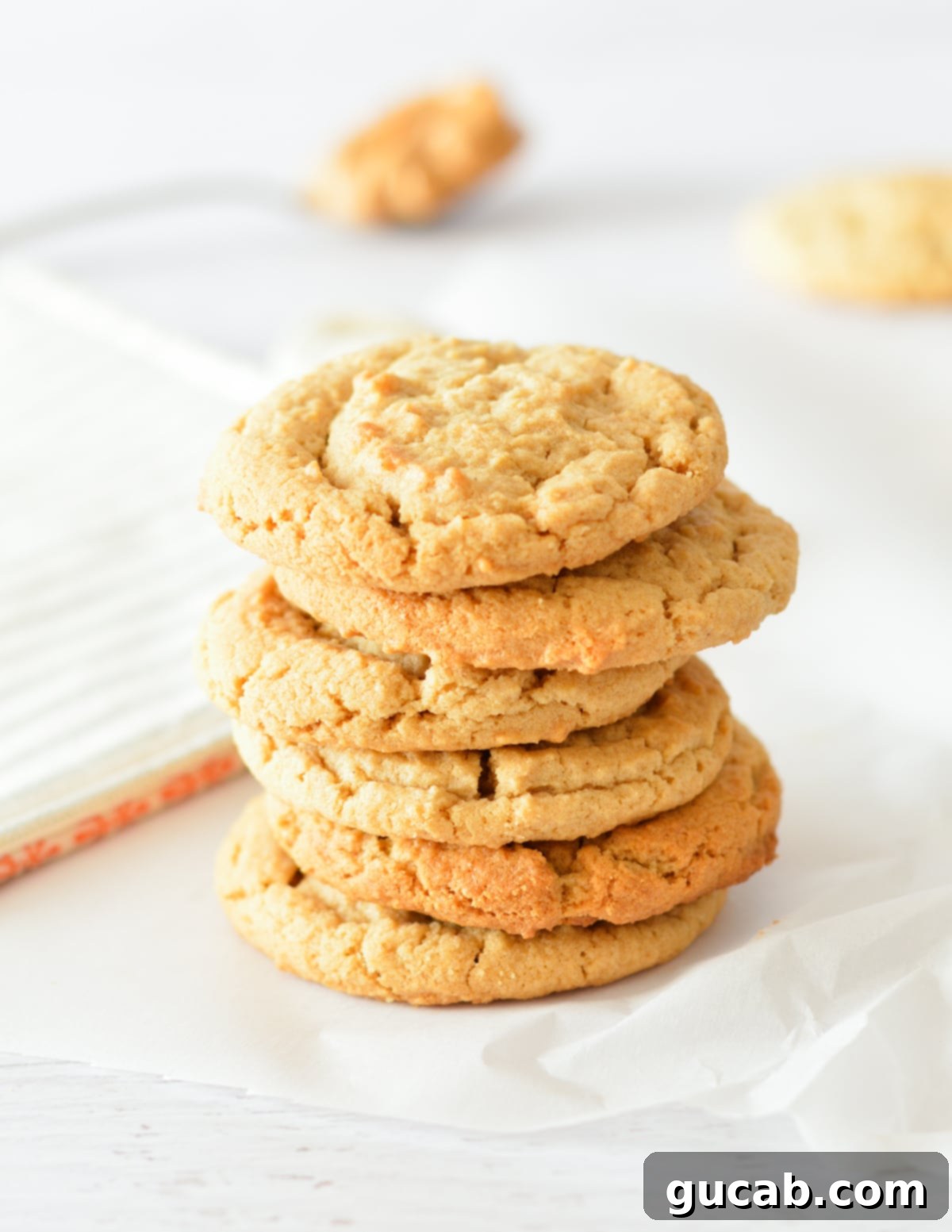 A stack of perfectly baked soft and chewy peanut butter cookies.