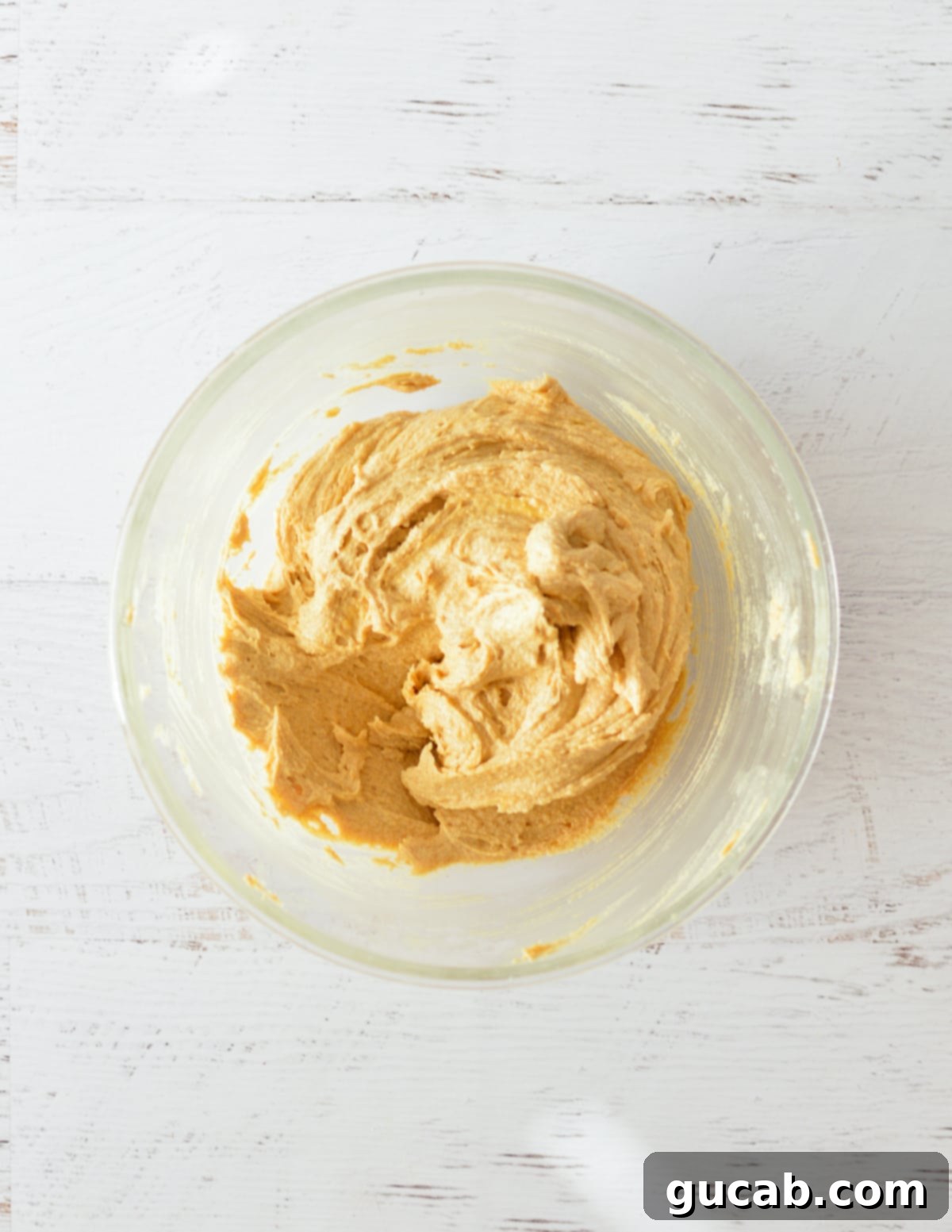Smooth peanut butter cookie dough in a mixing bowl after the egg has been incorporated.