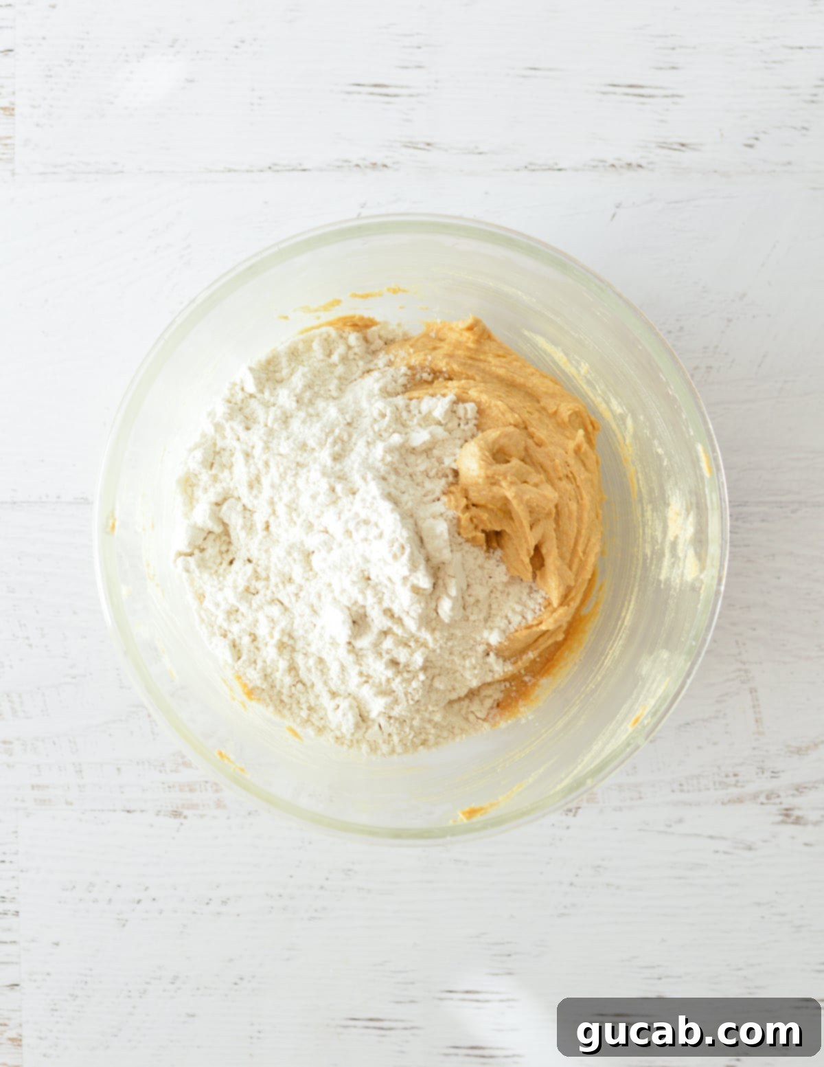 All-purpose flour, baking soda, and kosher salt sprinkled over the wet peanut butter mixture.