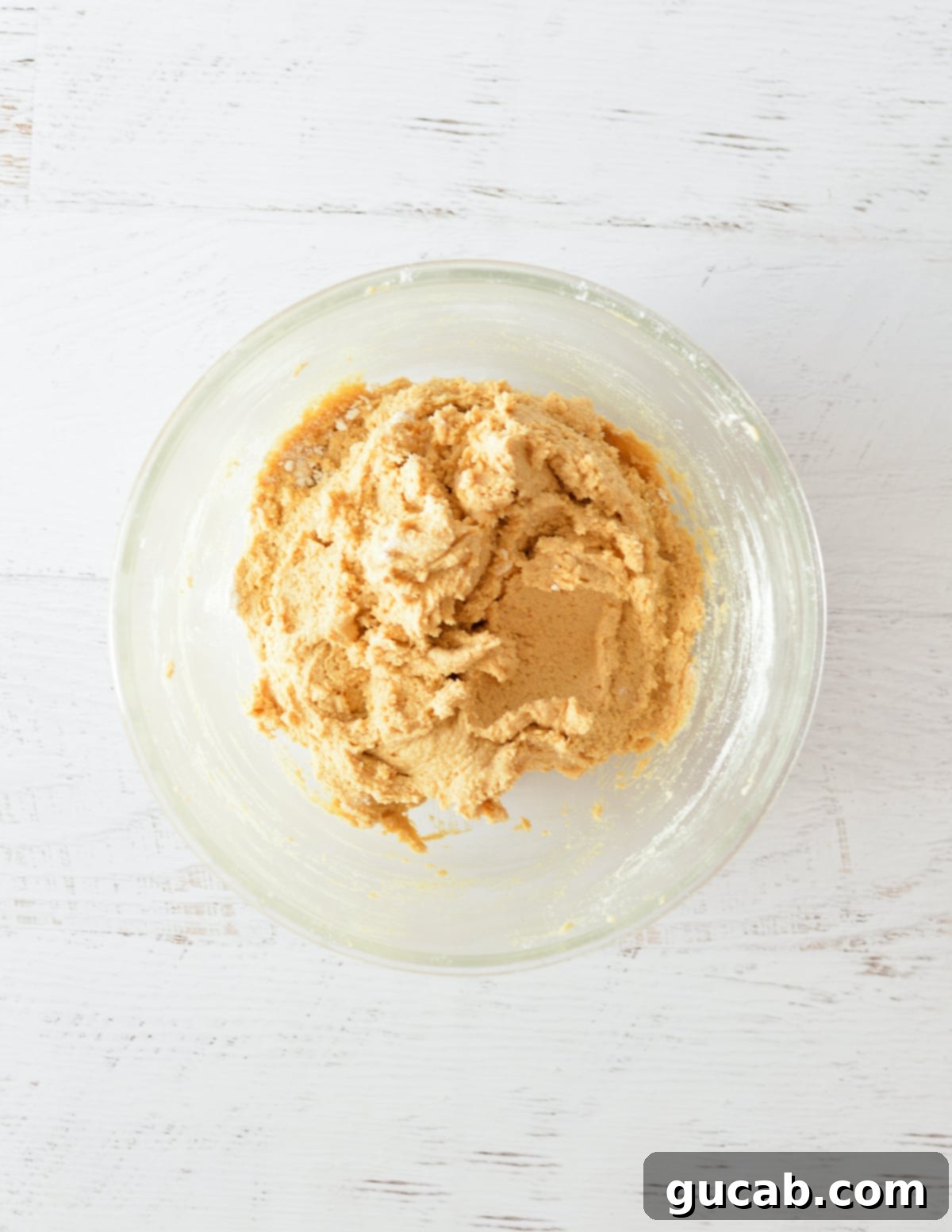 Smooth, well-mixed peanut butter cookie dough in a mixing bowl, ready for scooping.