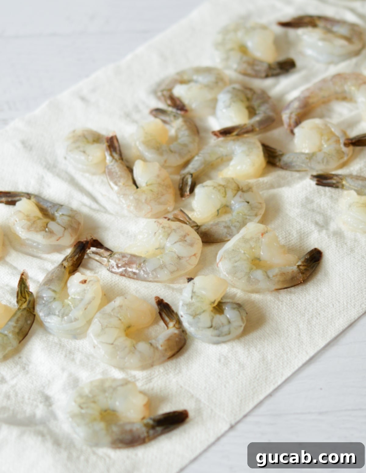 Thawed shrimp laid out on a paper towel, ready for drying.
