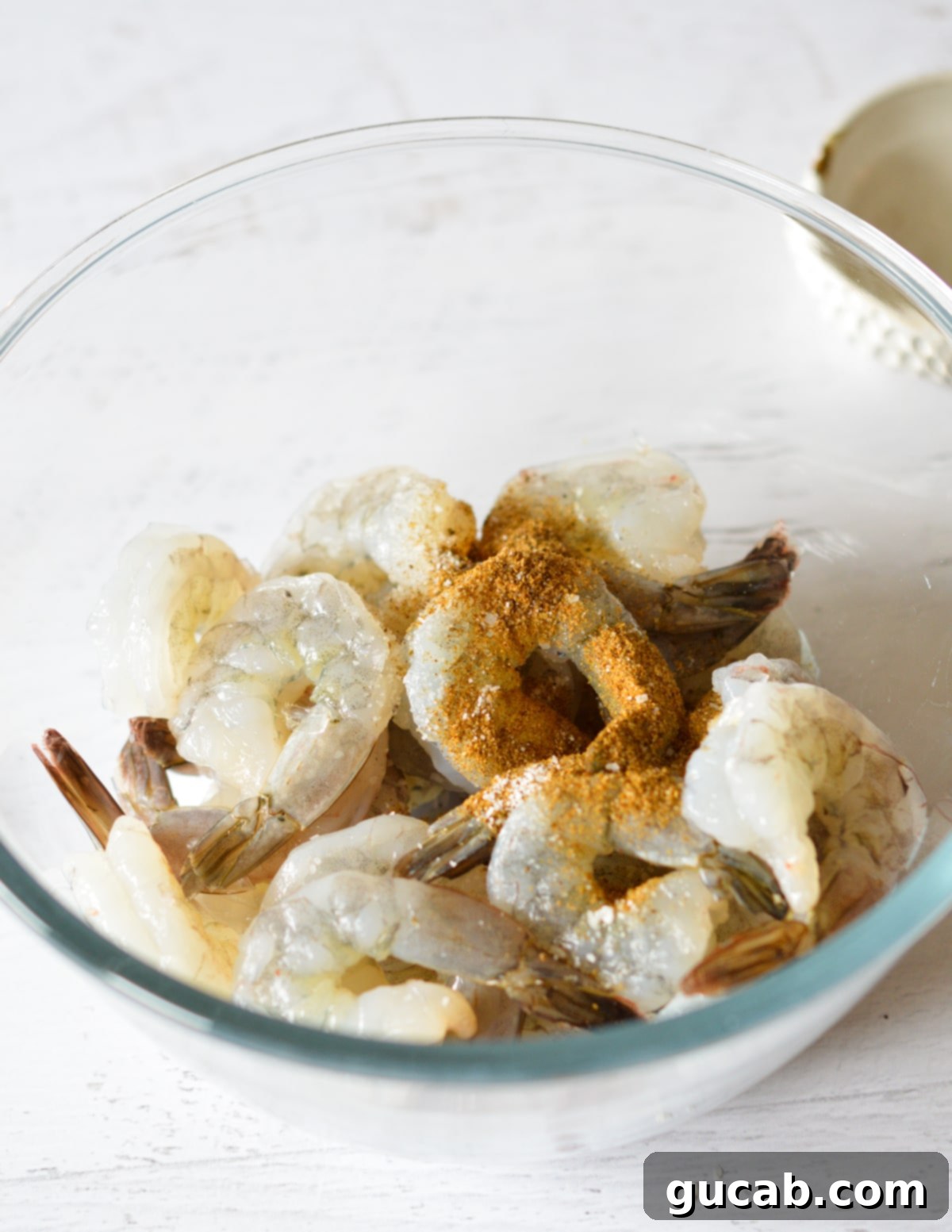 A bowl of dried shrimp with Old Bay seasoning sprinkled over them.