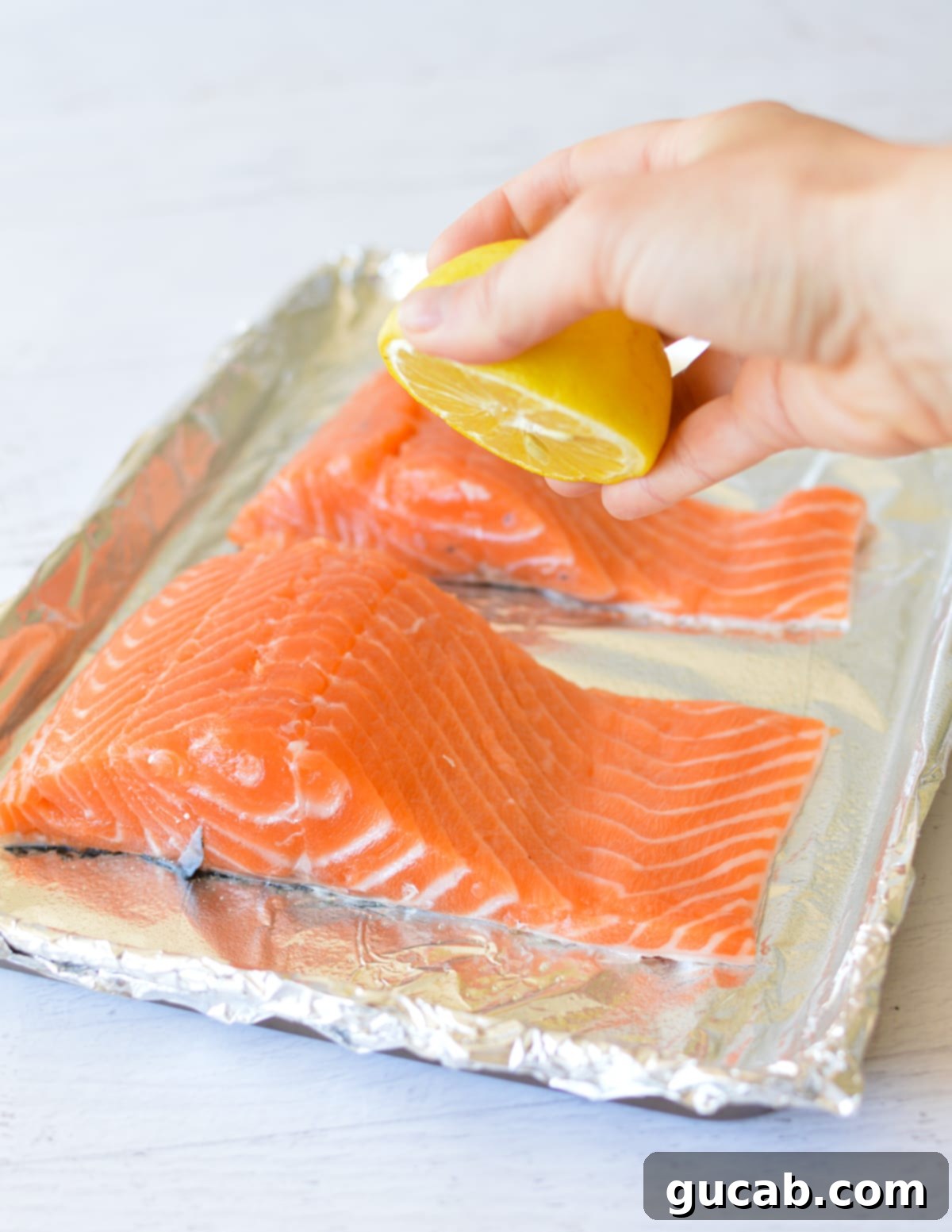 squeezing a lemon onto salmon fillets. 