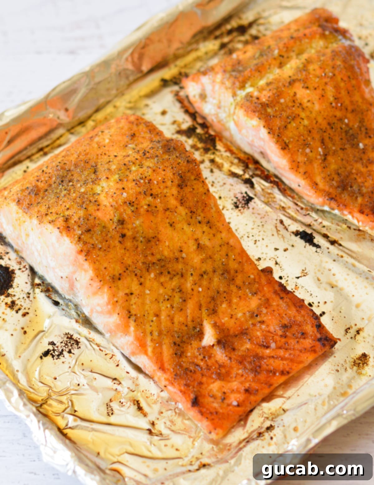 cooked lemon pepper salmon on sheet pan. 