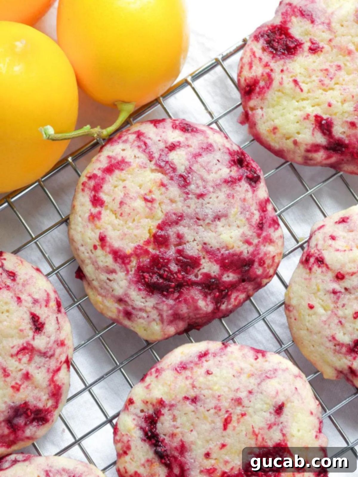 Next-Level Cookies: 25 Recipes You Need to Bake 9 Bright lemon raspberry cookies cooling on a wire rack.