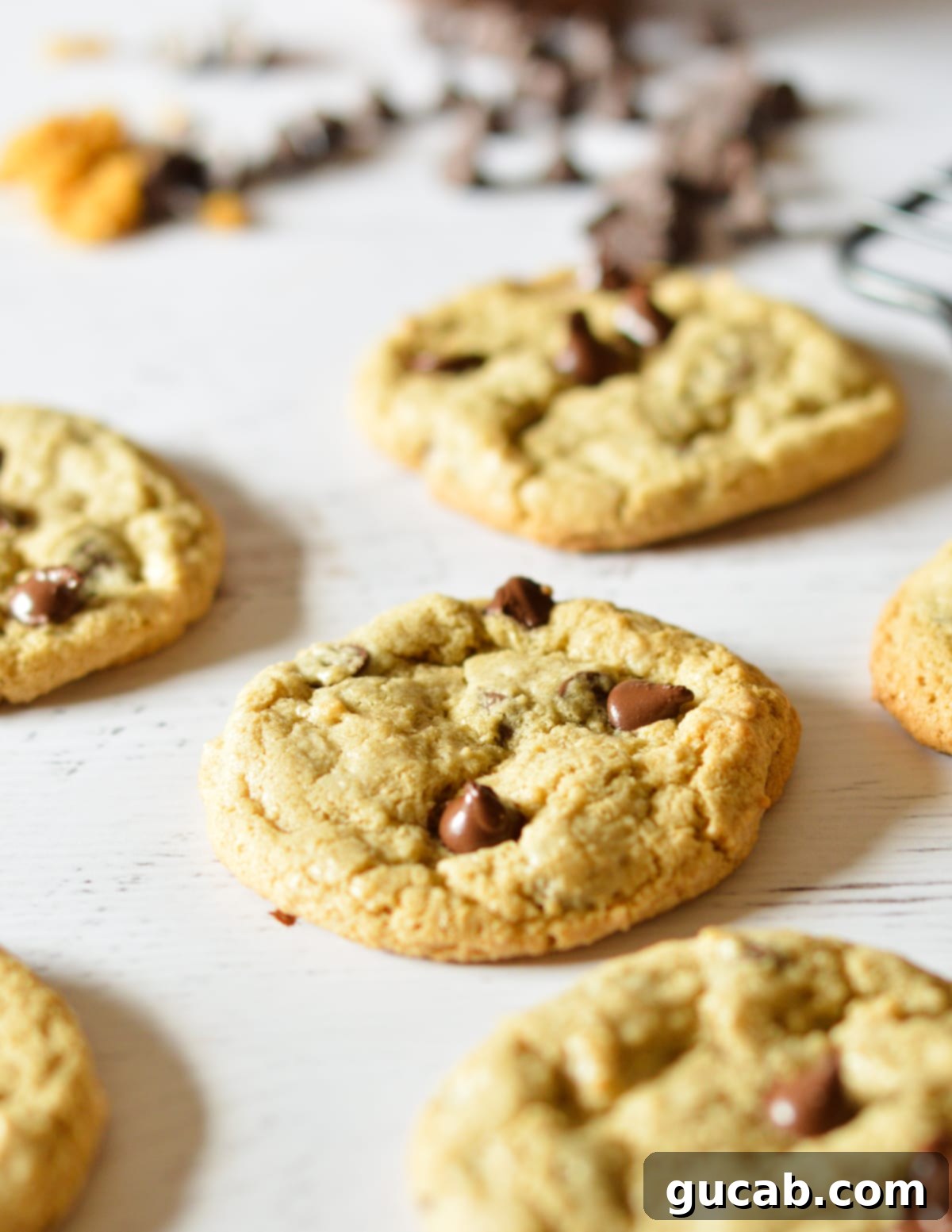 Several oat flour chocolate chip cookies cooling on a kitchen counter, showcasing their golden-brown edges and soft centers.