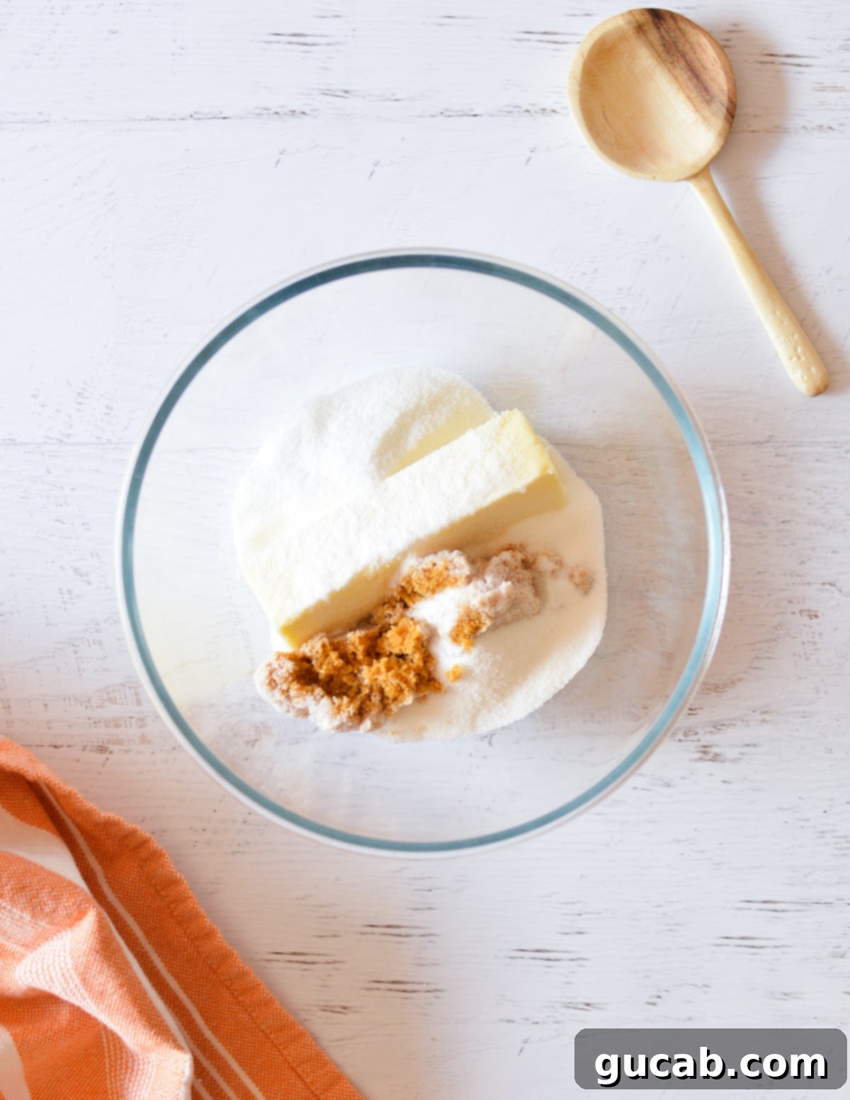 A mixing bowl containing softened unsalted butter, granulated sugar, and brown sugar, ready to be creamed.