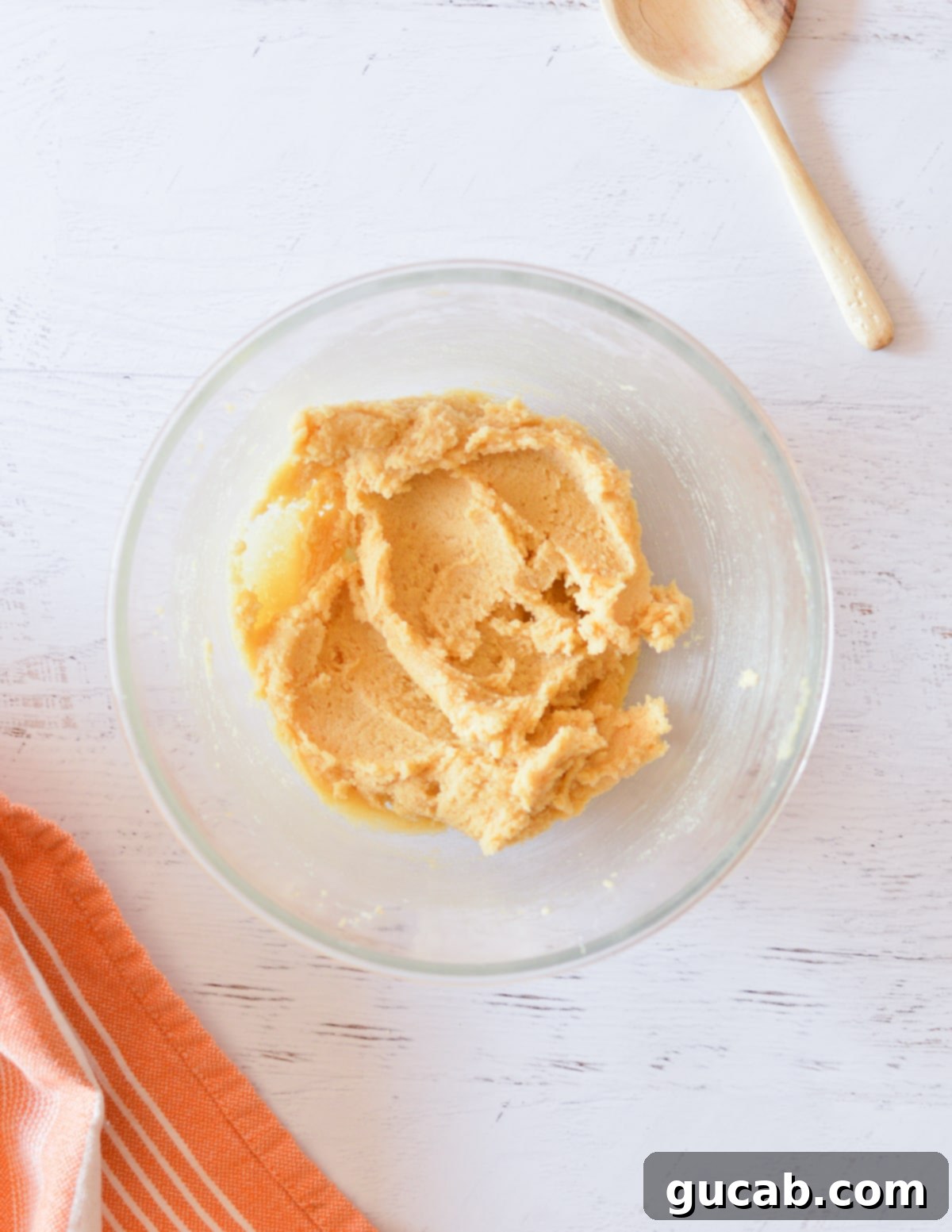 Close-up of butter and sugars creamed together, appearing light and fluffy in a mixing bowl.