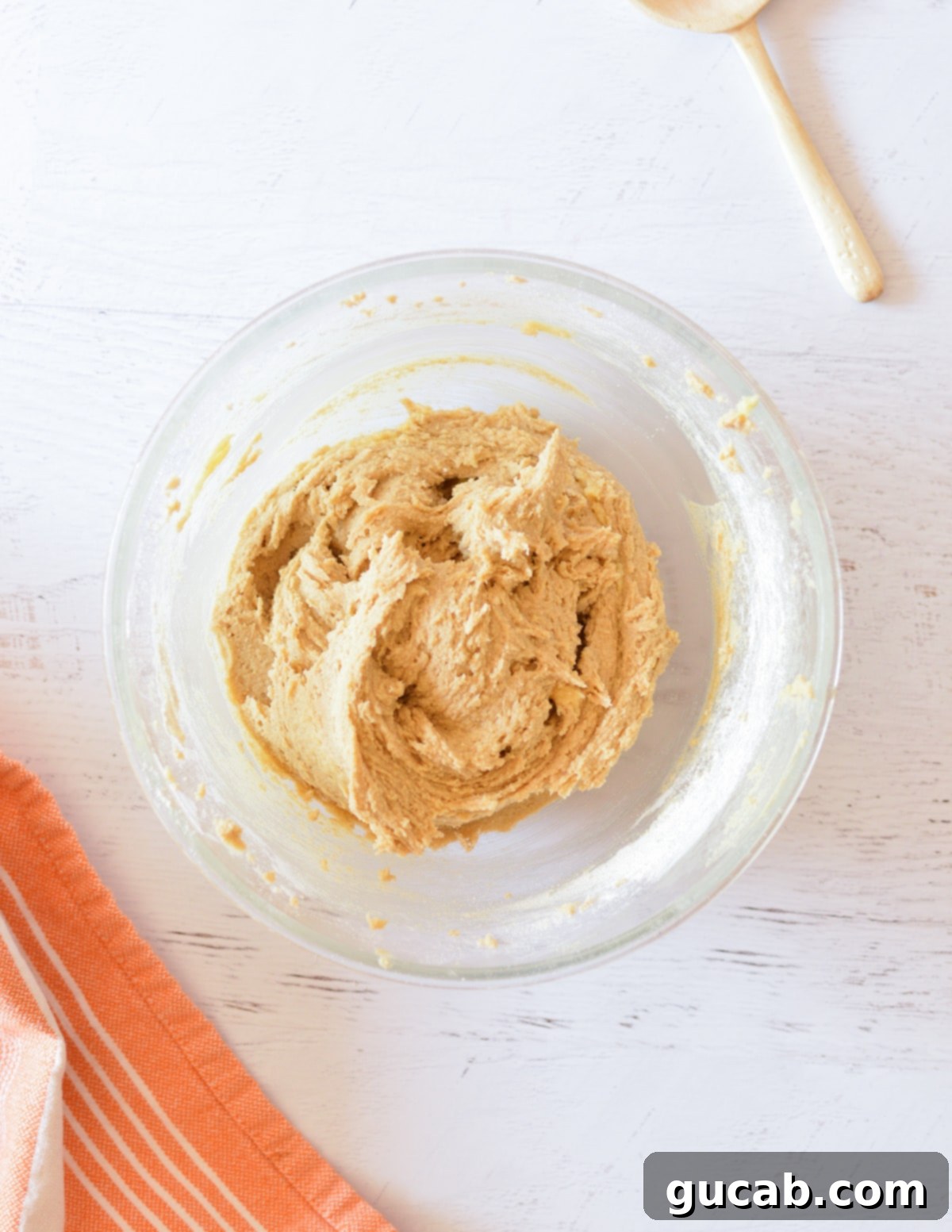 Smooth, light-brown oat flour cookie dough fully mixed in a stand mixer bowl.