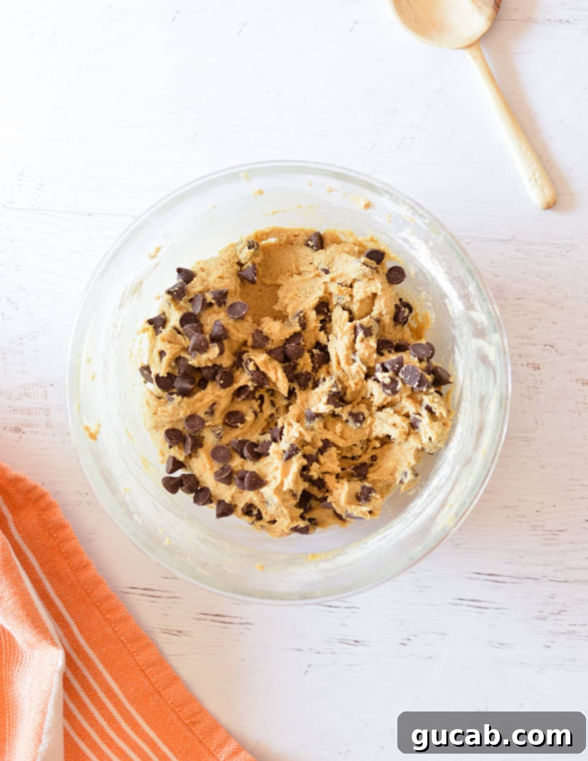 Oat flour chocolate chip cookie dough in a mixing bowl with chocolate chips evenly distributed throughout.