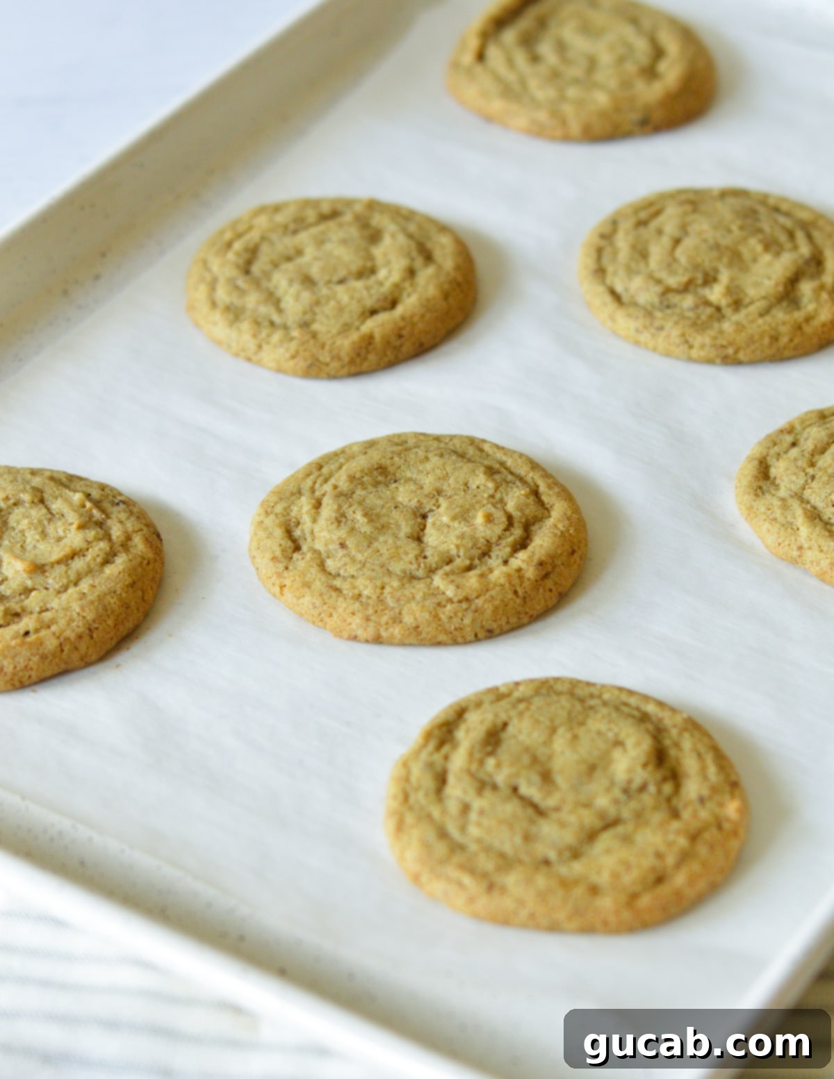 Freshly baked coffee cookies cooling on a sheet pan, with golden edges and soft centers.