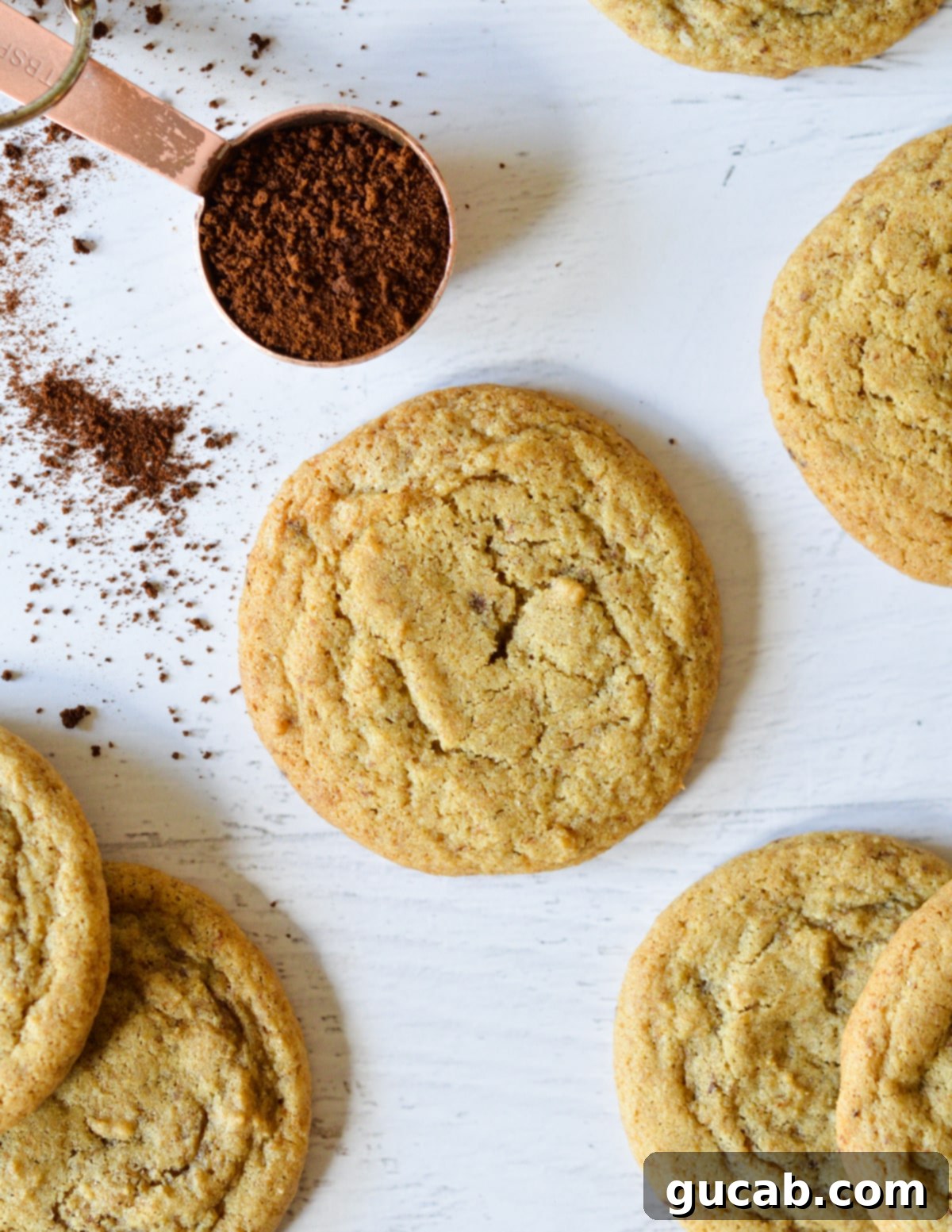 One coffee cookie resting beside several other cookies, suggesting a batch of baked goods.