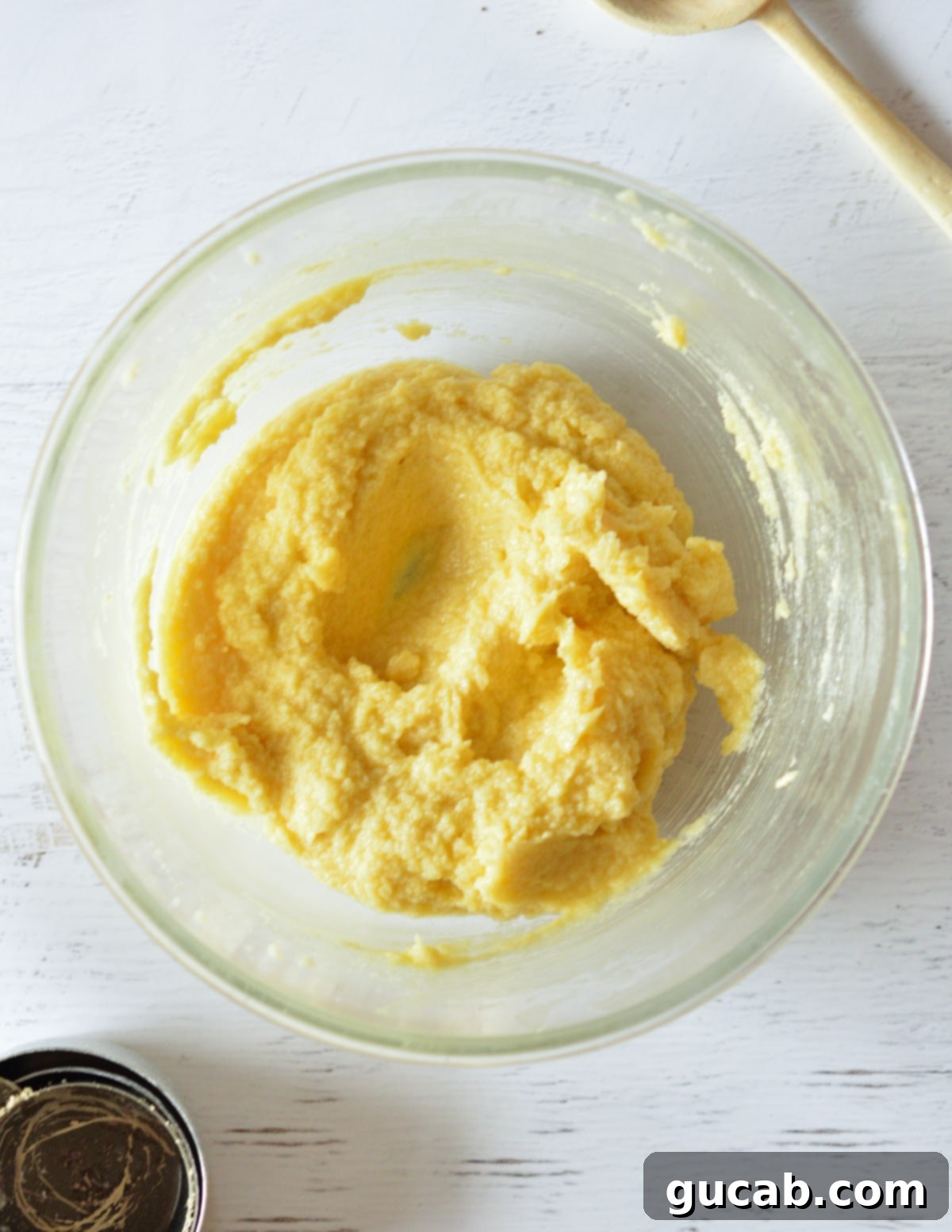 A bowl showing a thoroughly combined butter, sugar, and egg mixture, with scraped-down sides.