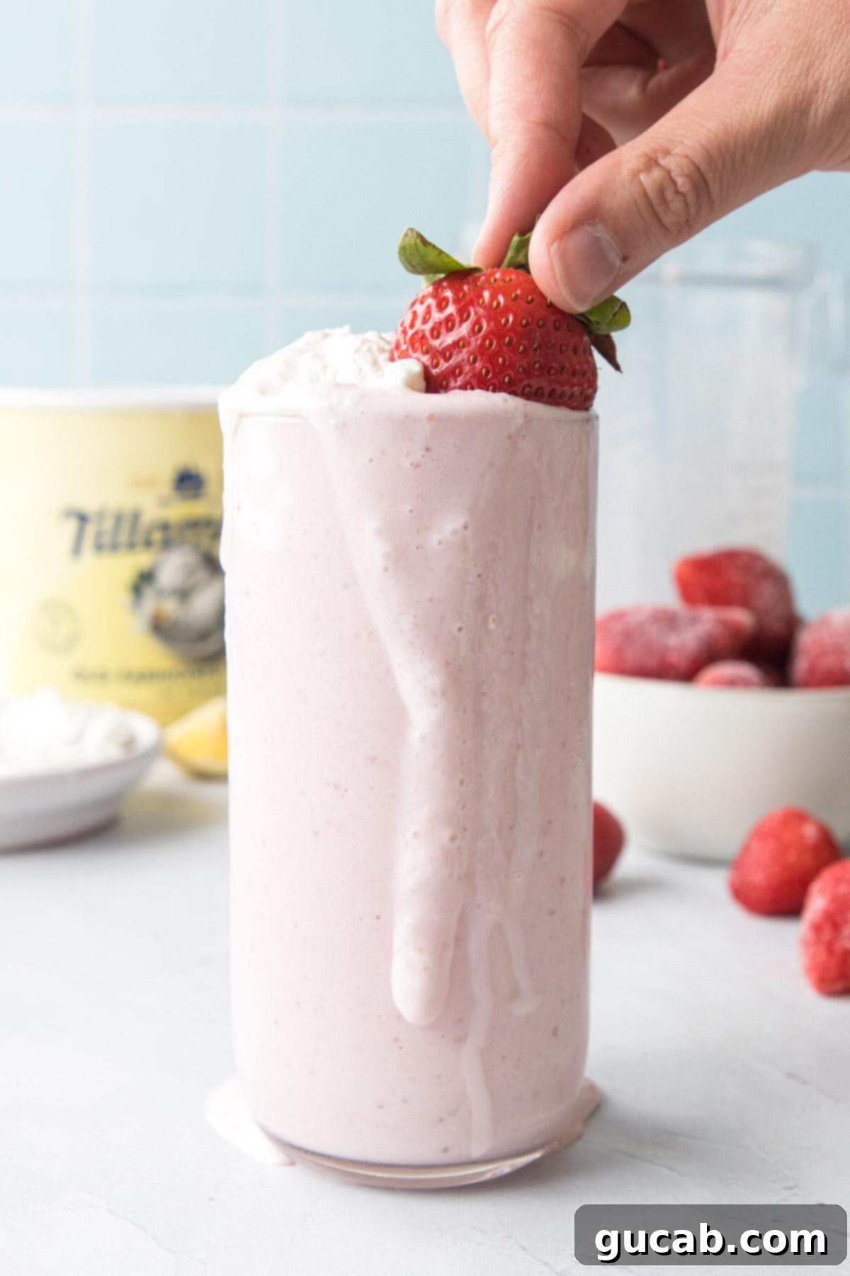 strawberry banana milkshake with whipped cream and strawberry on top. 