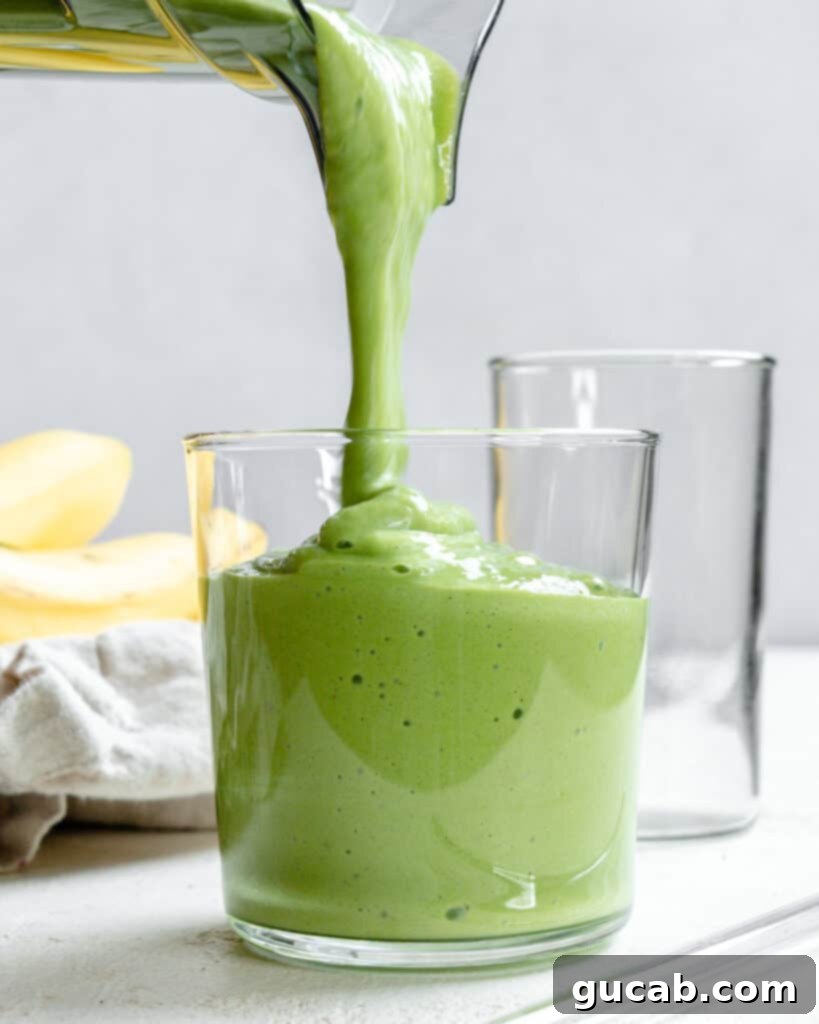 pouring a banana kale smoothie into a glass. 