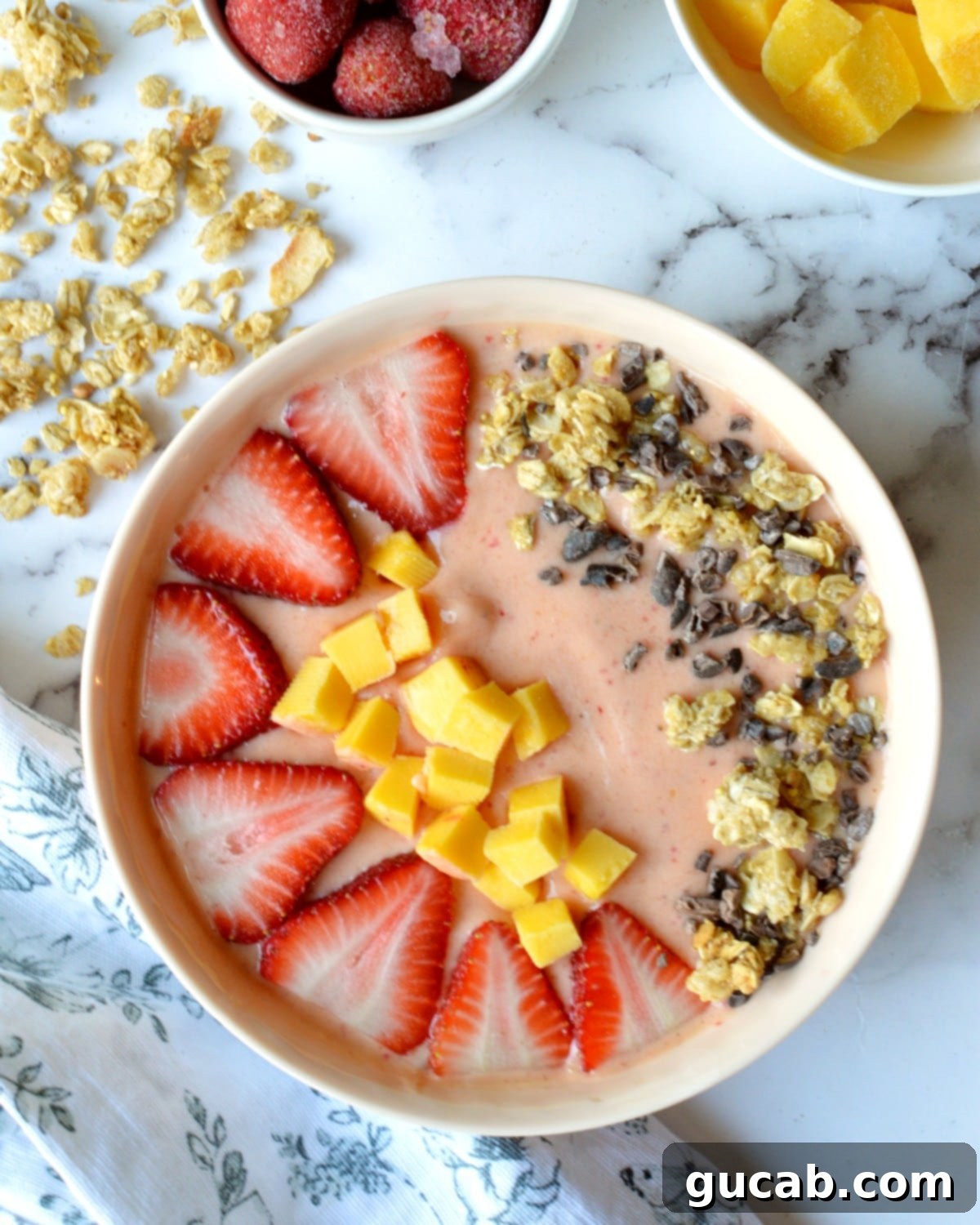 strawberry mango smoothie bowl with toppings.