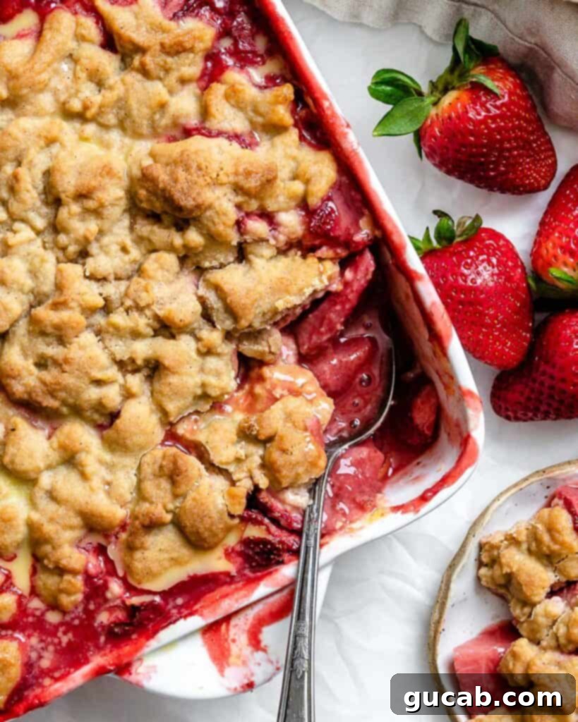 a spoon in a strawberry crumble.