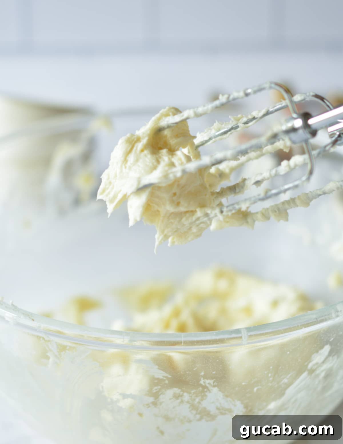 Mixing beaters covered in freshly made, creamy cream cheese frosting.