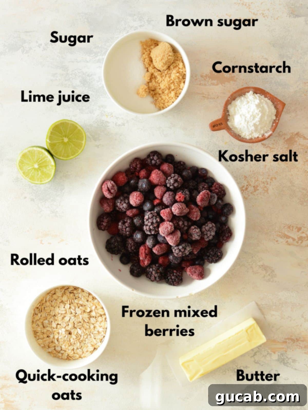 A collection of fresh and pantry ingredients laid out for making a triple berry crisp, including frozen berries, oats, sugars, and butter.