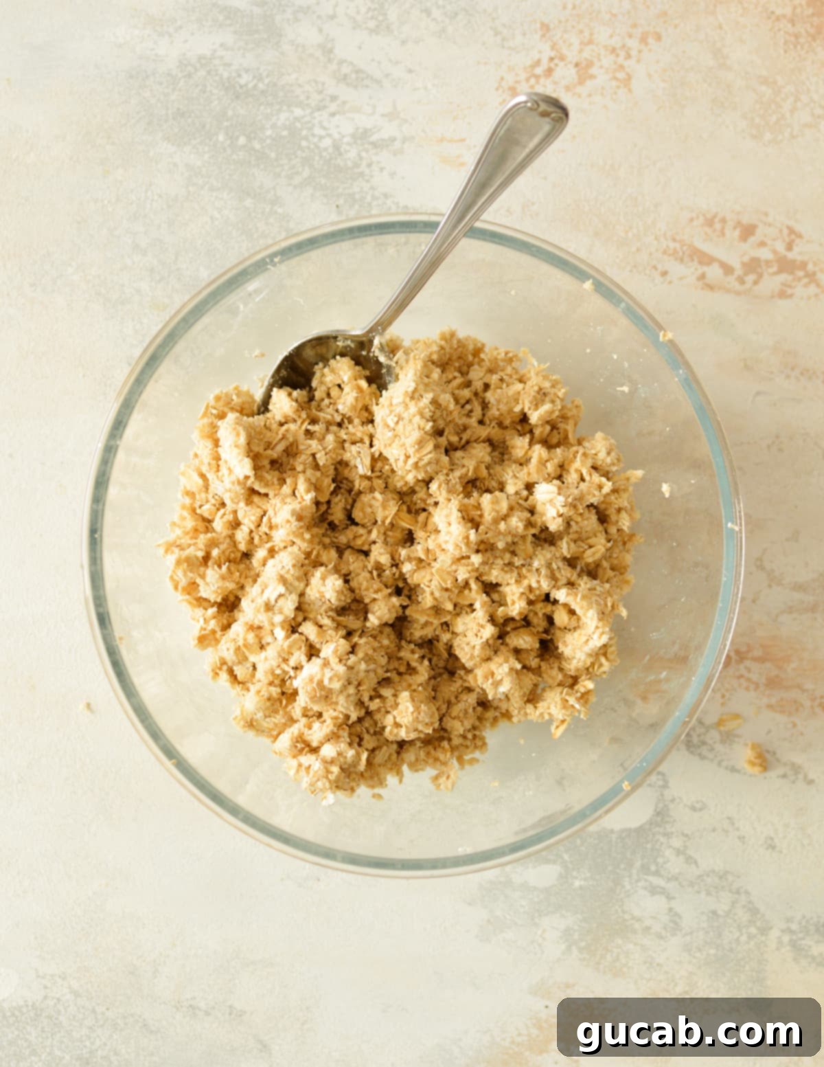 A perfectly crumbly oat topping mixture in a bowl, with the butter fully incorporated, ready to be sprinkled over the berries.