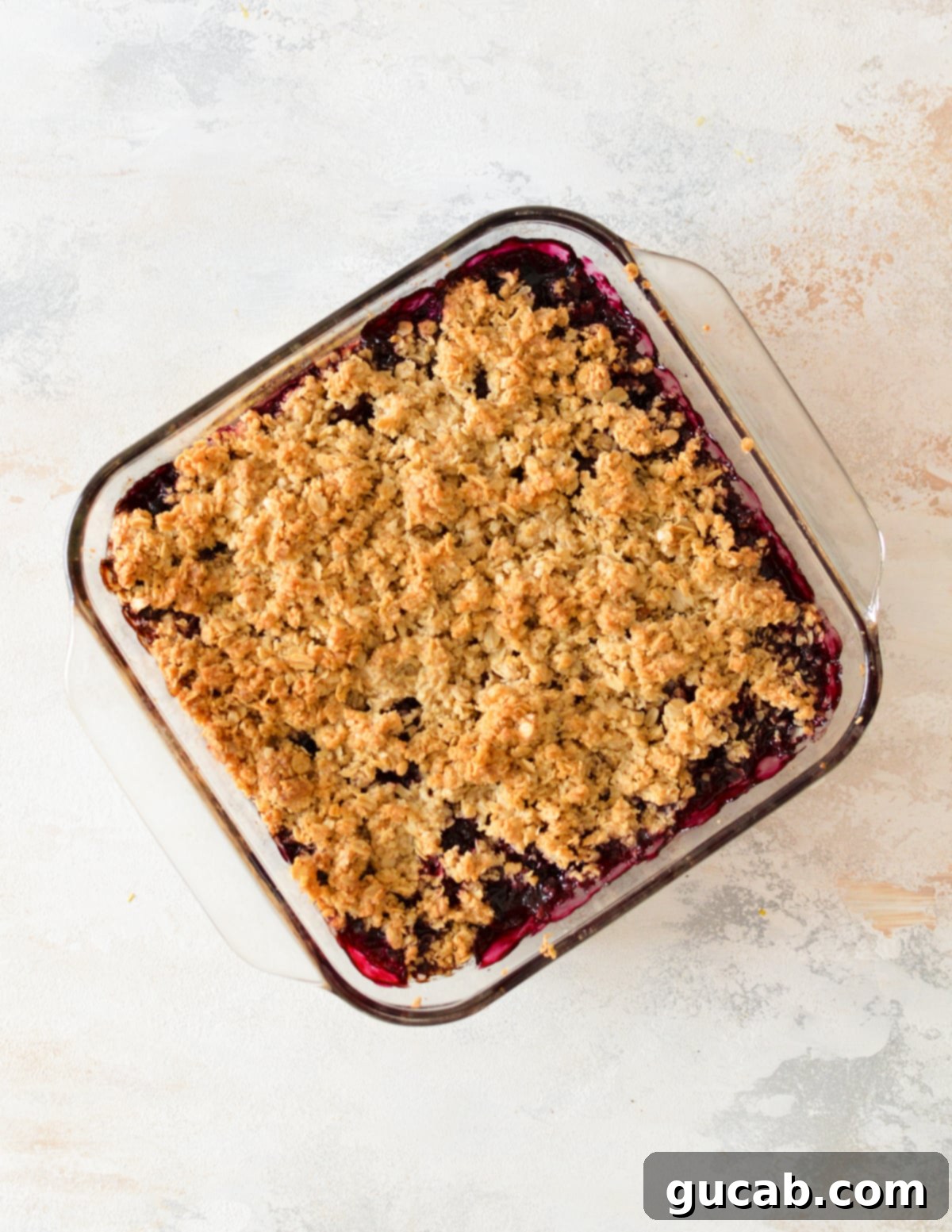 A freshly baked, bubbling mixed berry crisp, hot from the oven, with a golden-brown and crispy oat topping.