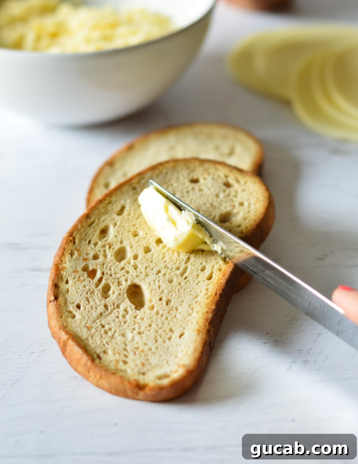 Gourmet Provolone Grilled Cheese 4 knife with butter on a slice of bread.