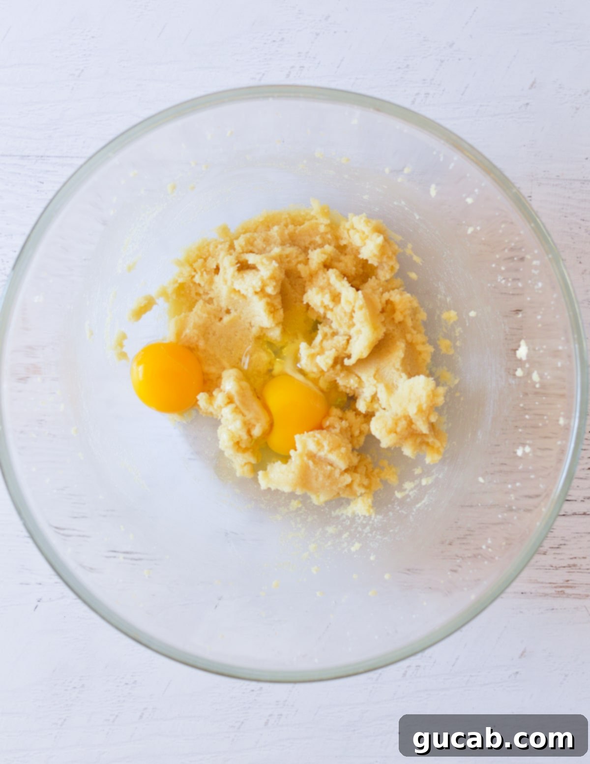 Creamed butter and sugar with eggs on top, ready to be mixed.
