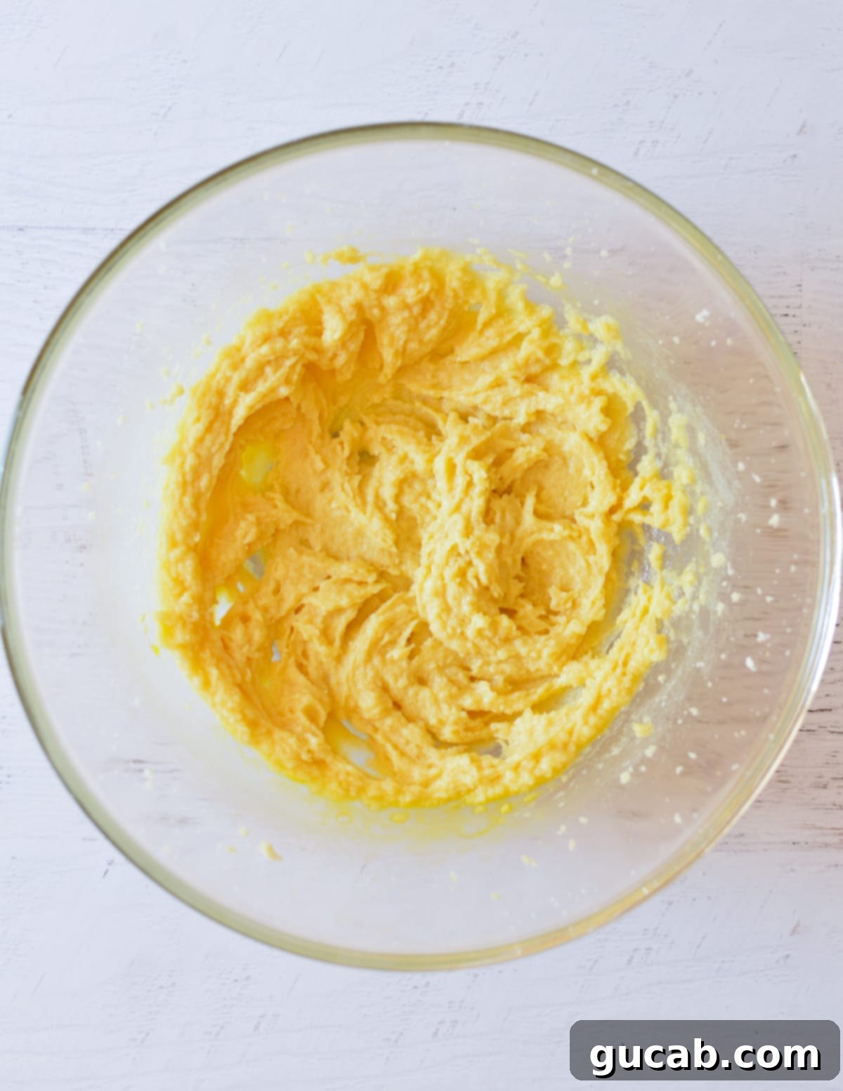 Eggs fully incorporated into the butter and sugar mixture, forming a smooth batter.