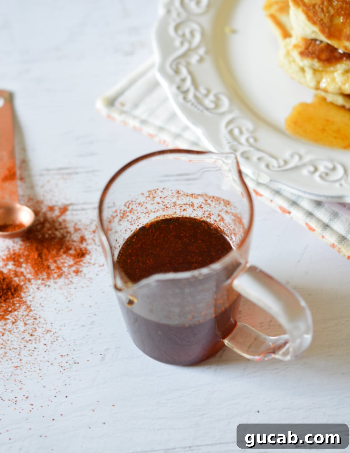 A glass bottle of homemade spicy maple syrup, ready to be enjoyed, highlighting its beautiful amber color.