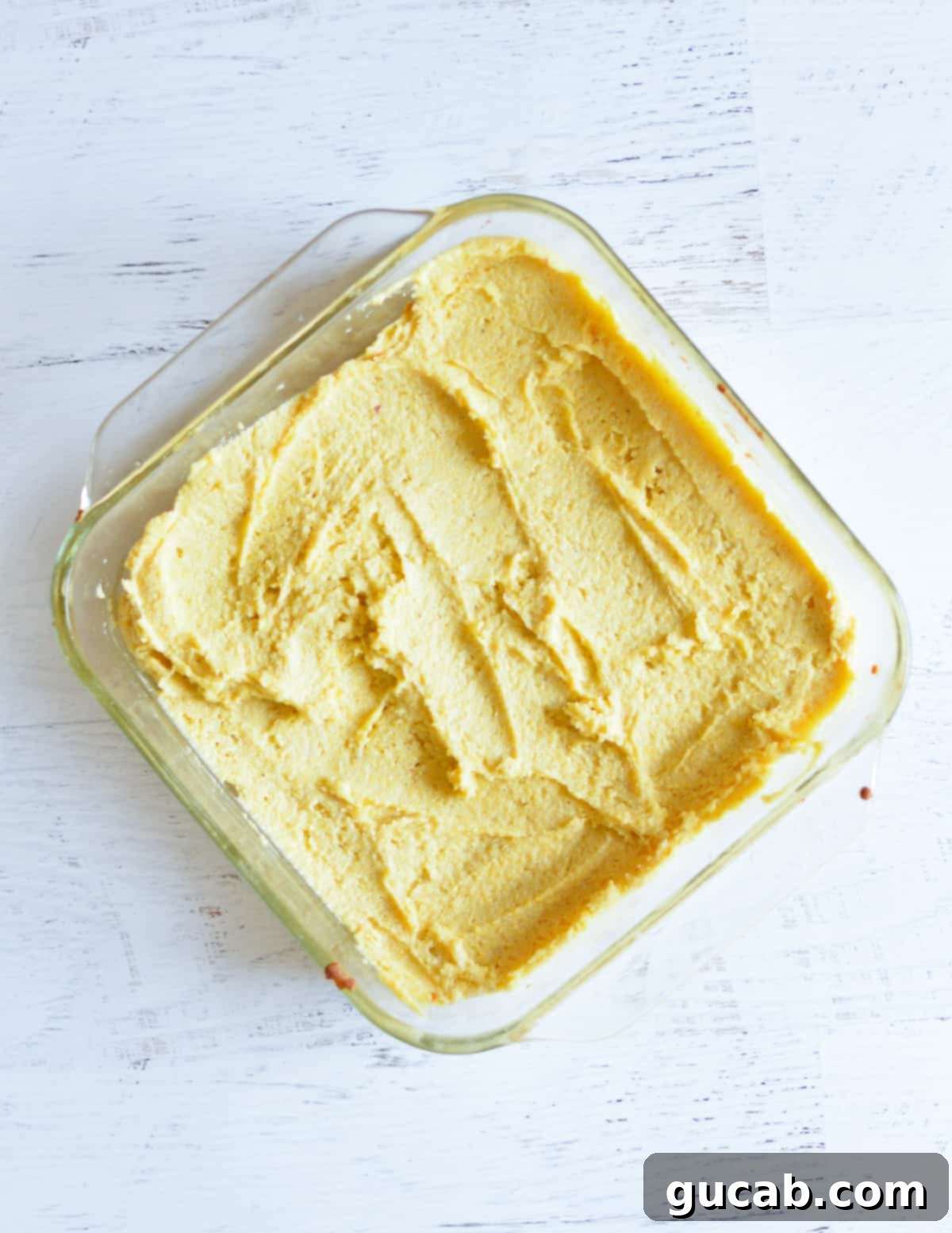 unbaked cornbread in a glass baking dish. 